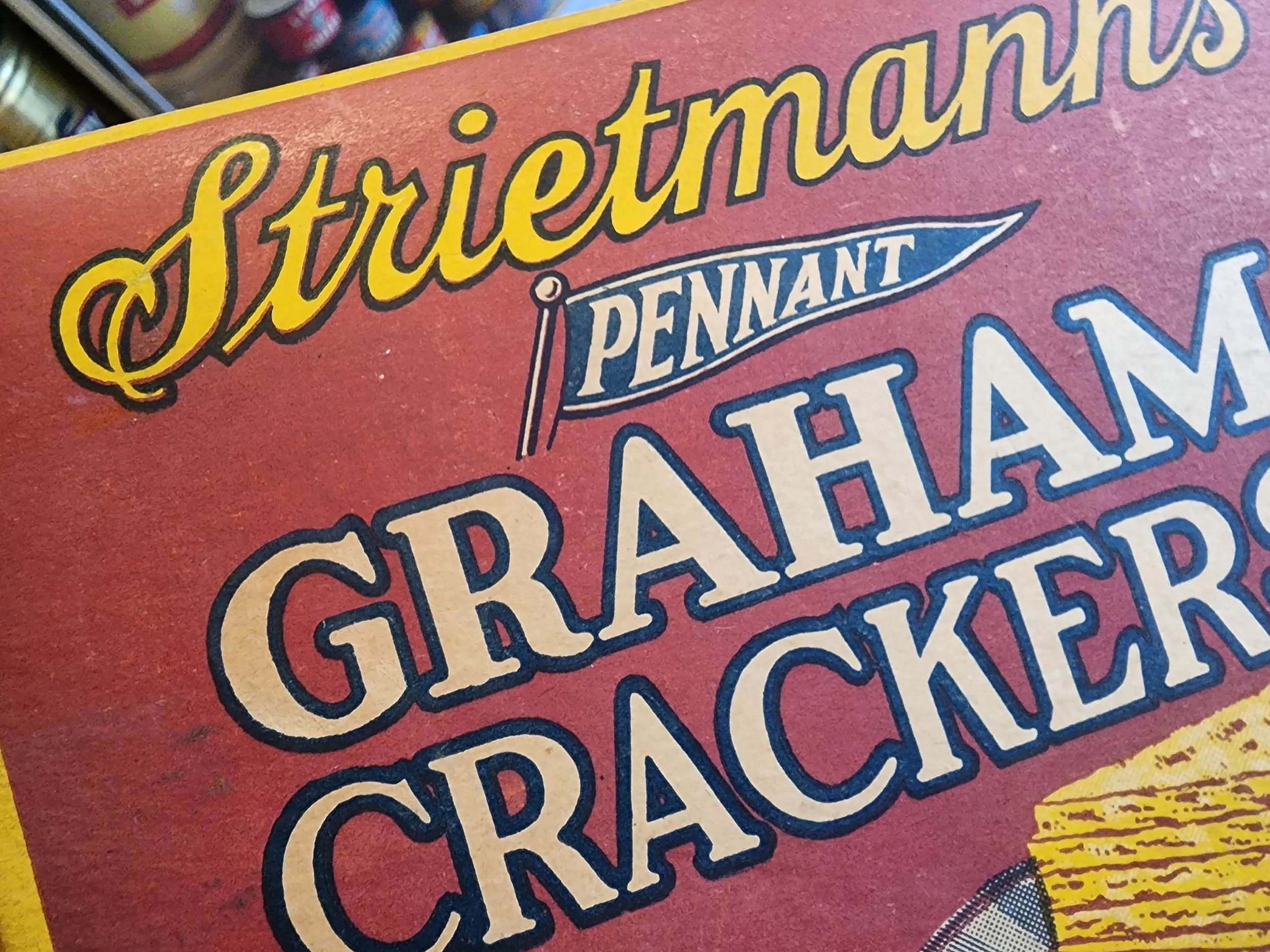 Close-up of a vintage box of Pennant Cheddar cheese with decorative lettering and design.