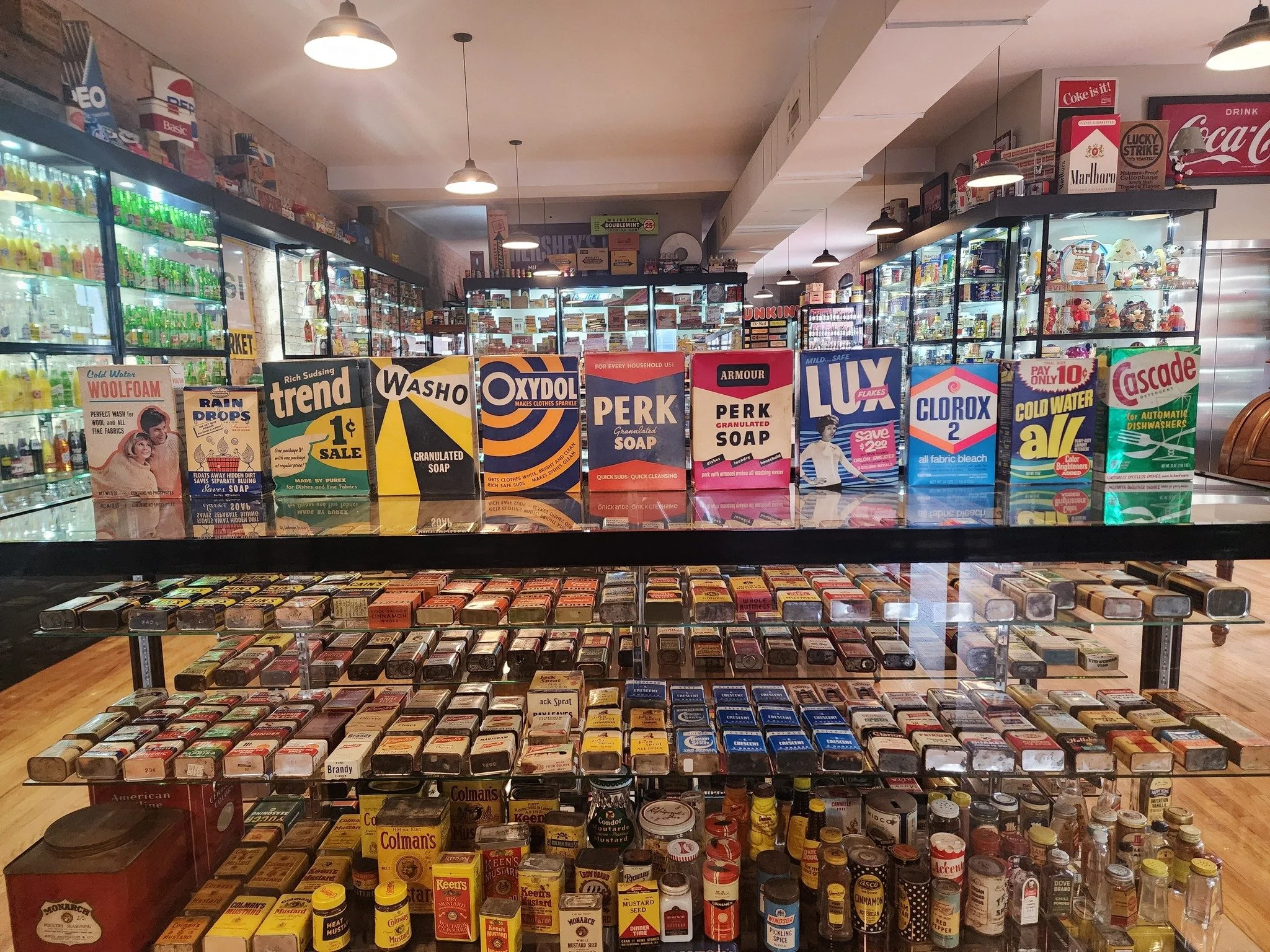 View of the Chicago Brand Museum with shelves stocked with baking and cooking ingredients, including spices, sauces, and condiments along with other artifacts.