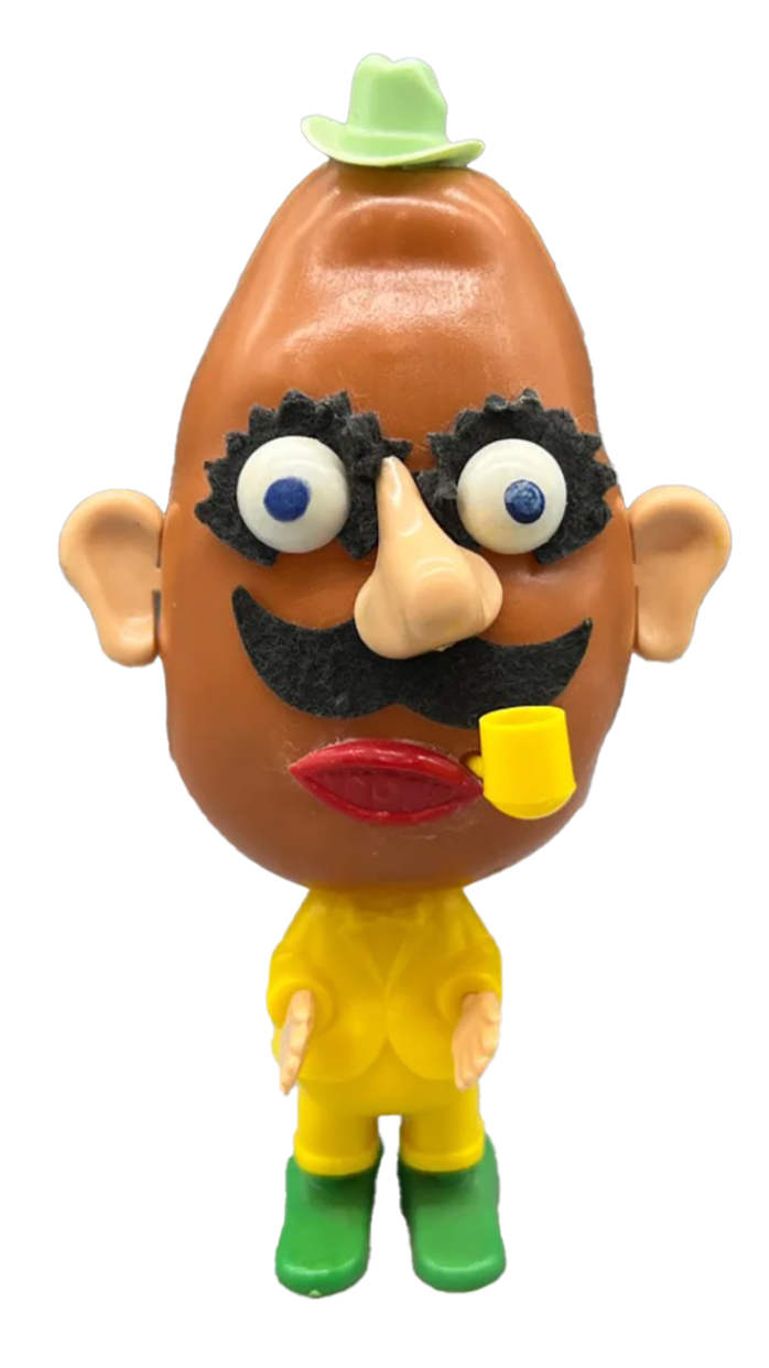 Toy figure with a large head, wearing a small green hat, yellow raincoat, and green boots, with exaggerated facial features including a mustache, glasses, and a pipe.