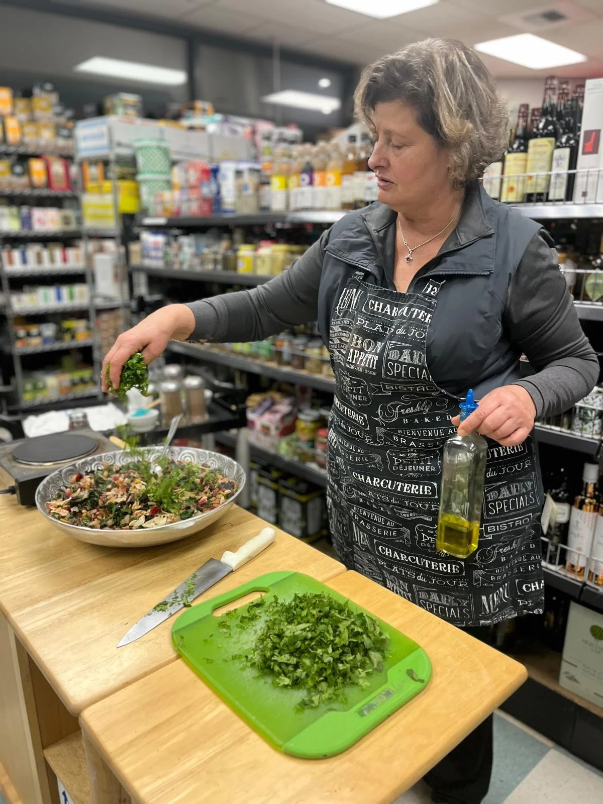 nahla gholam chopping up parsley and mixing in a salad bowl
