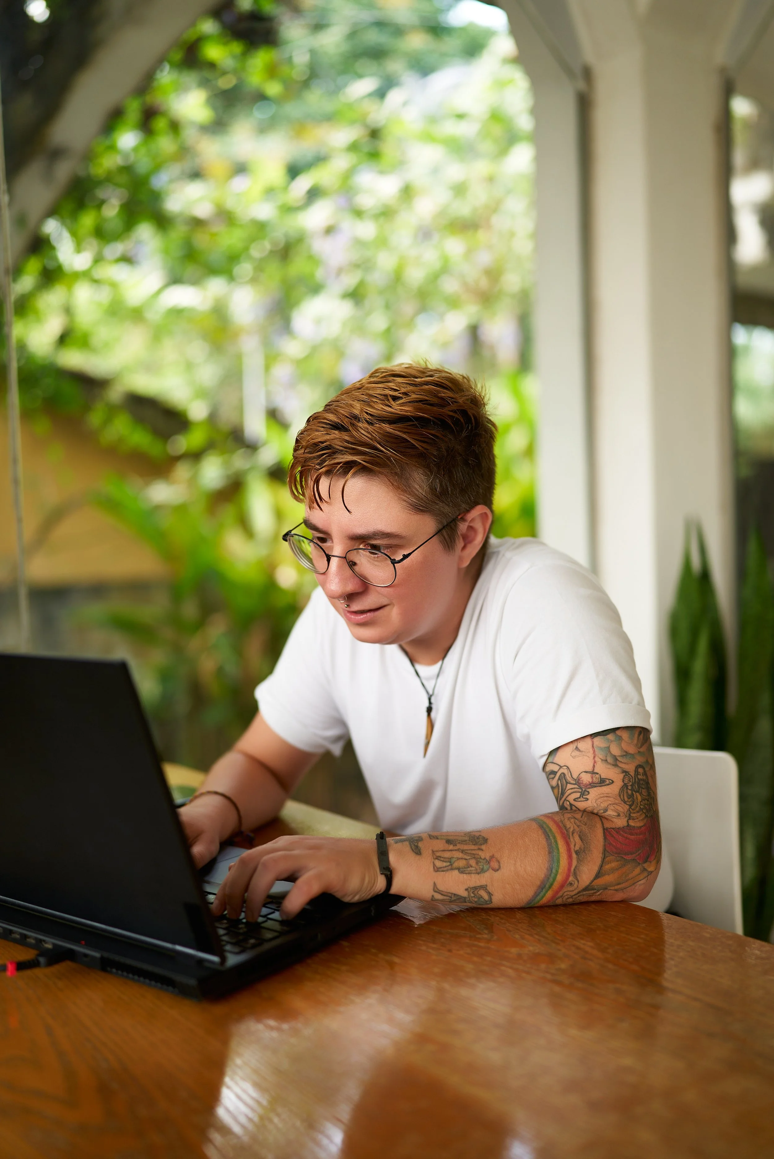 Nonbinary person working on their laptop