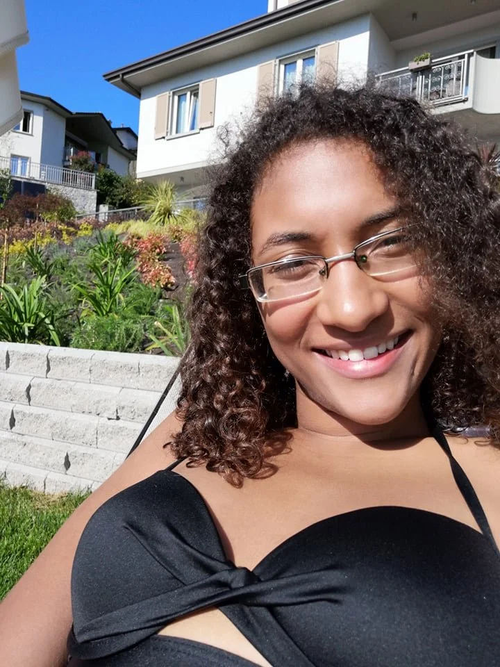 Picture of Elisa, owner of the web design studio, "Design for Changemakers", she is basking in the sun in a black bikini, and we can see her looking directly at the camera smiling..jpg