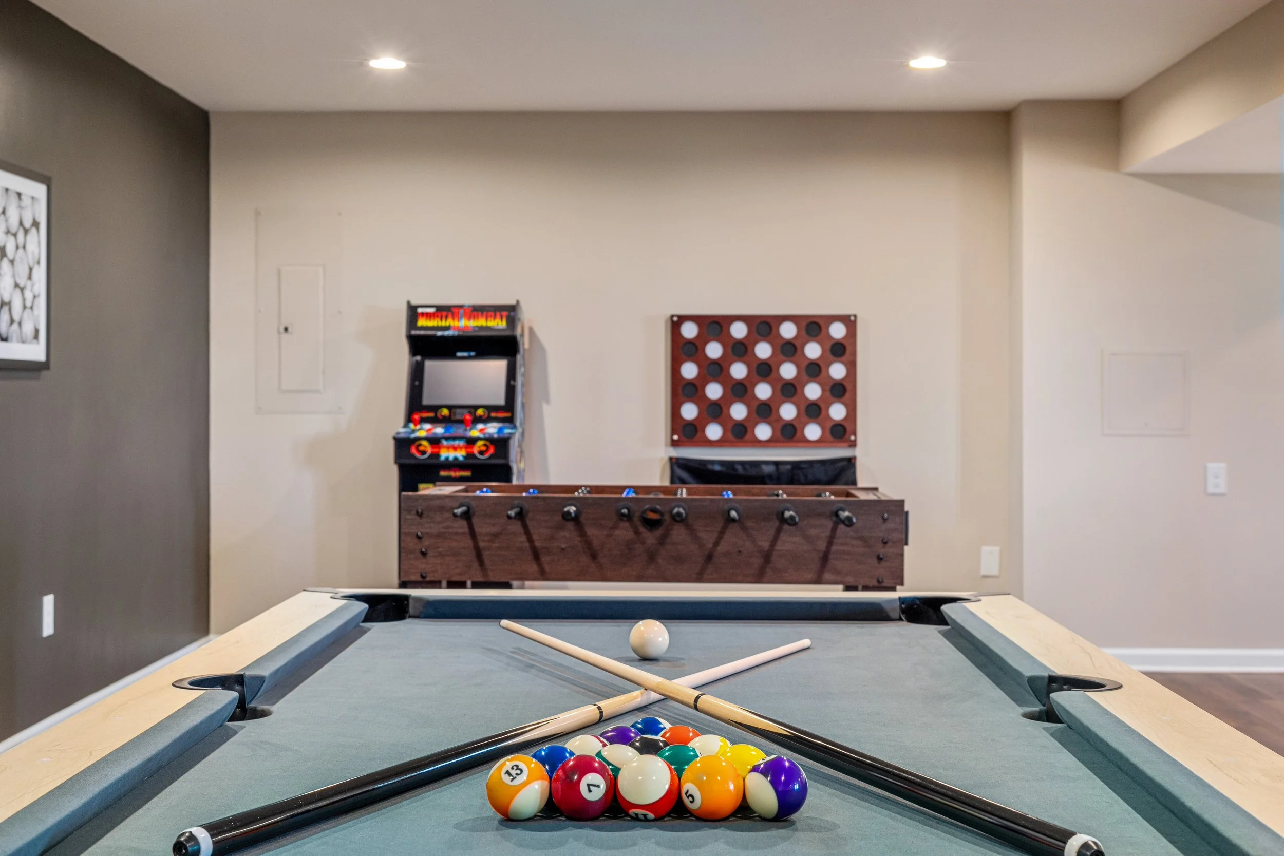 Indoor game room with a pool table, foosball table, and an arcade machine