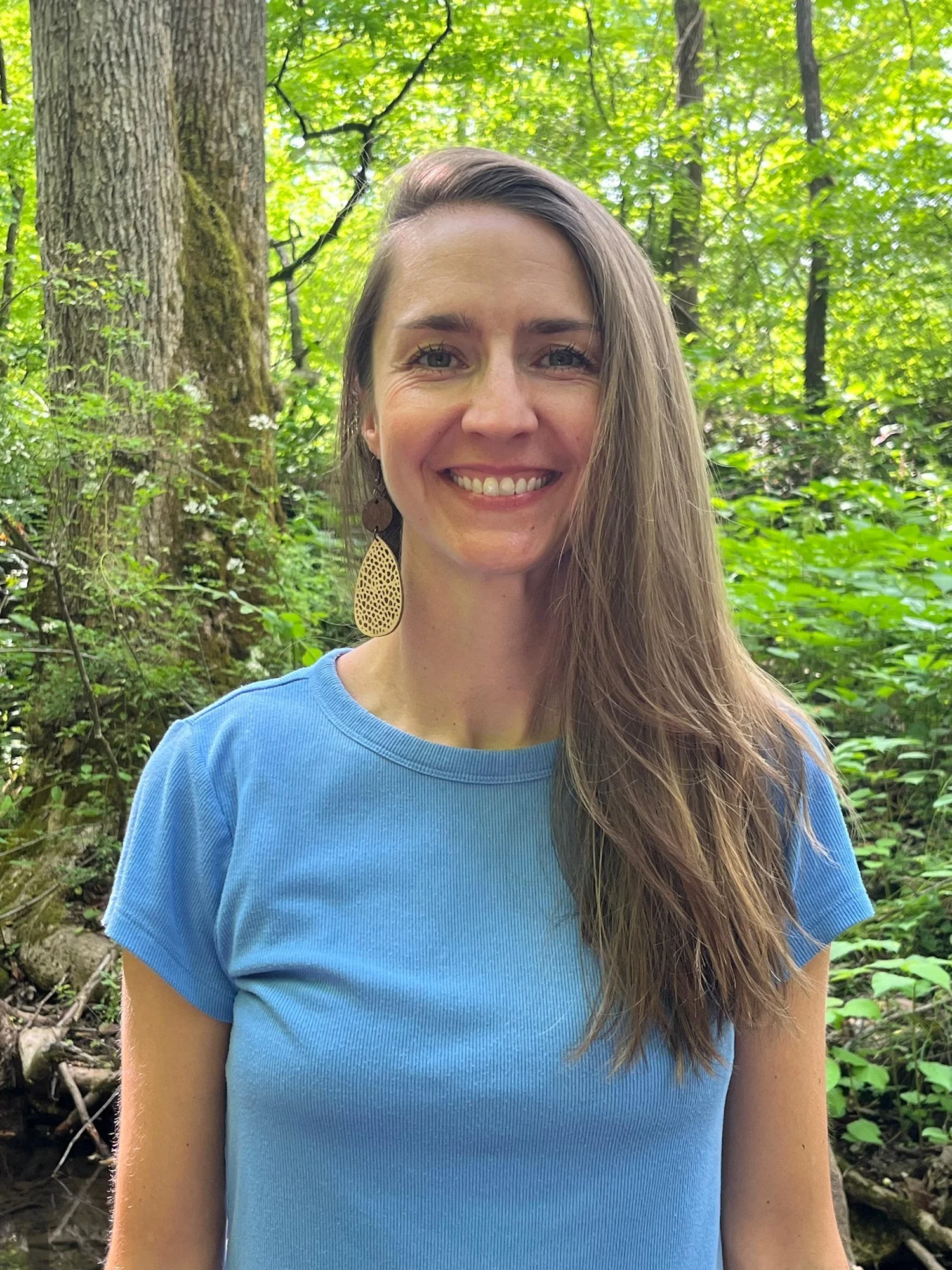 Alex Rice, Ayurvedic Practitioner in Asheville, North Carolina, smiling warmly in the woods