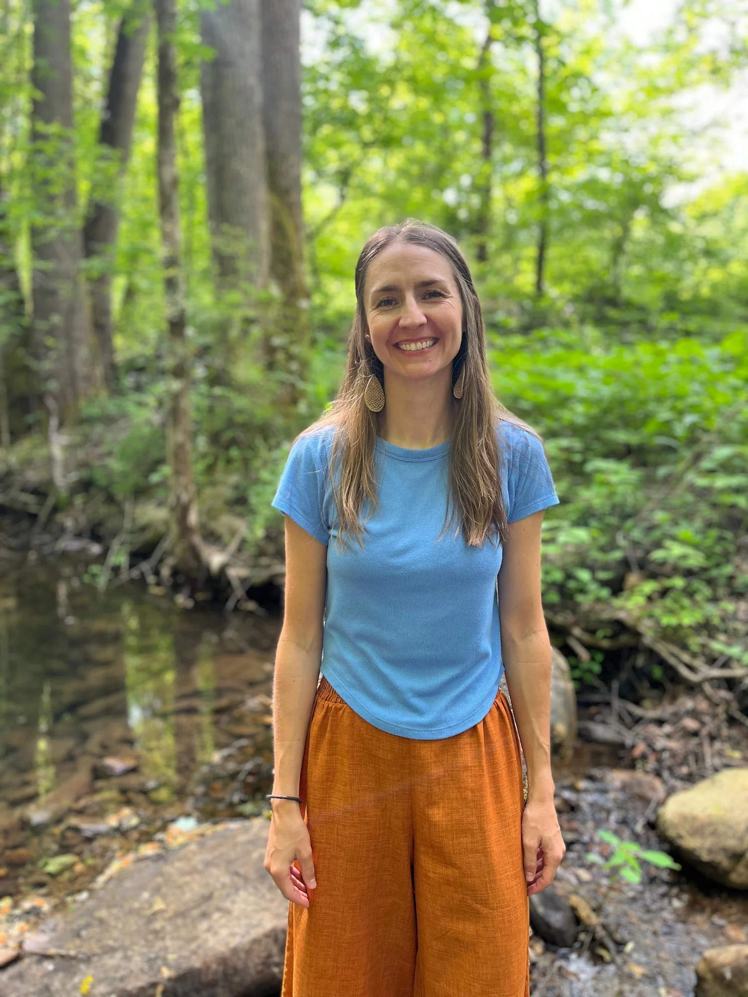Alex Rice, Ayurvedic Practitioner, standing by a creek in the Asheville area of western North Carolina