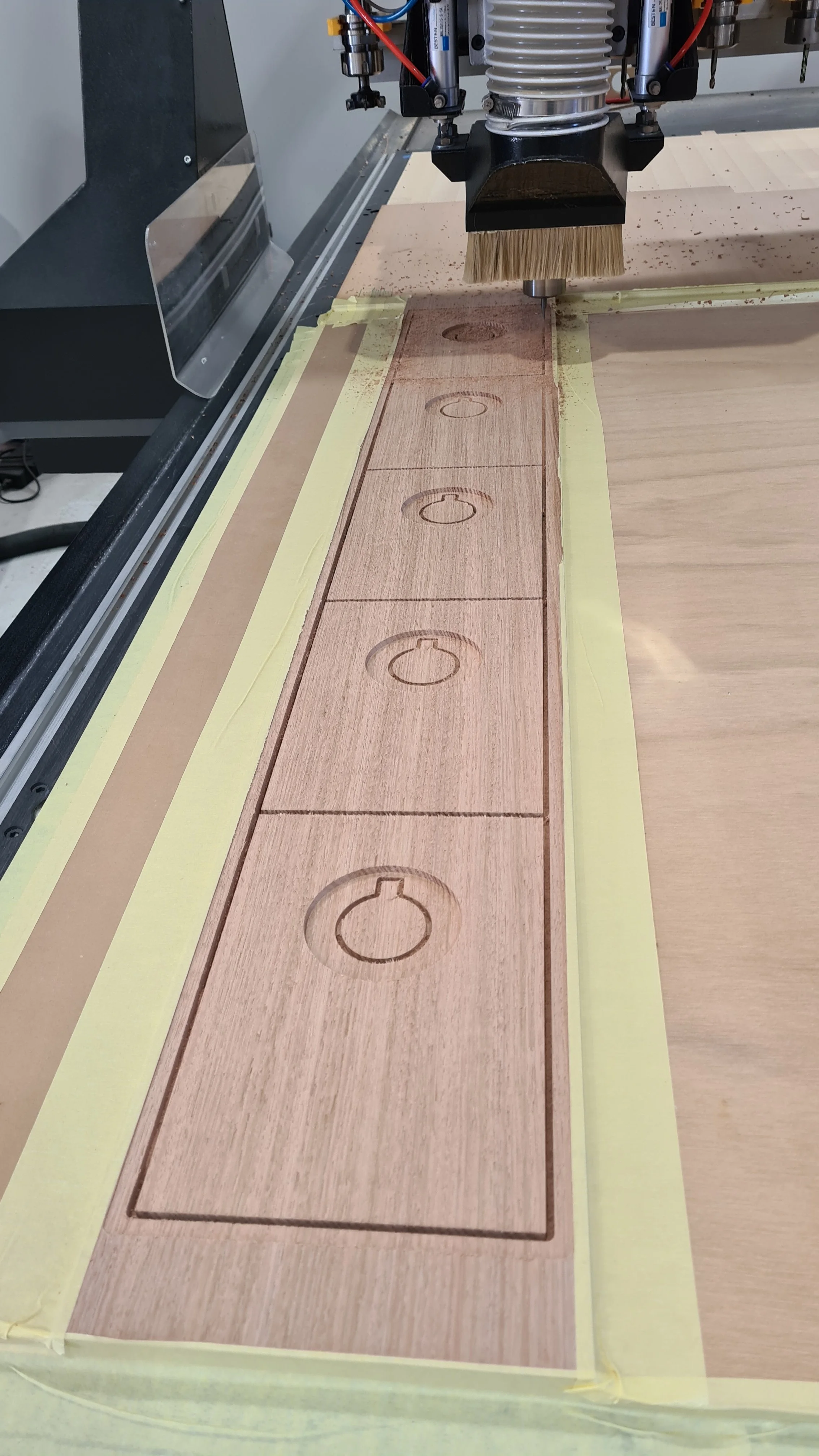 A CNC machine carving circular designs into wooden panels.