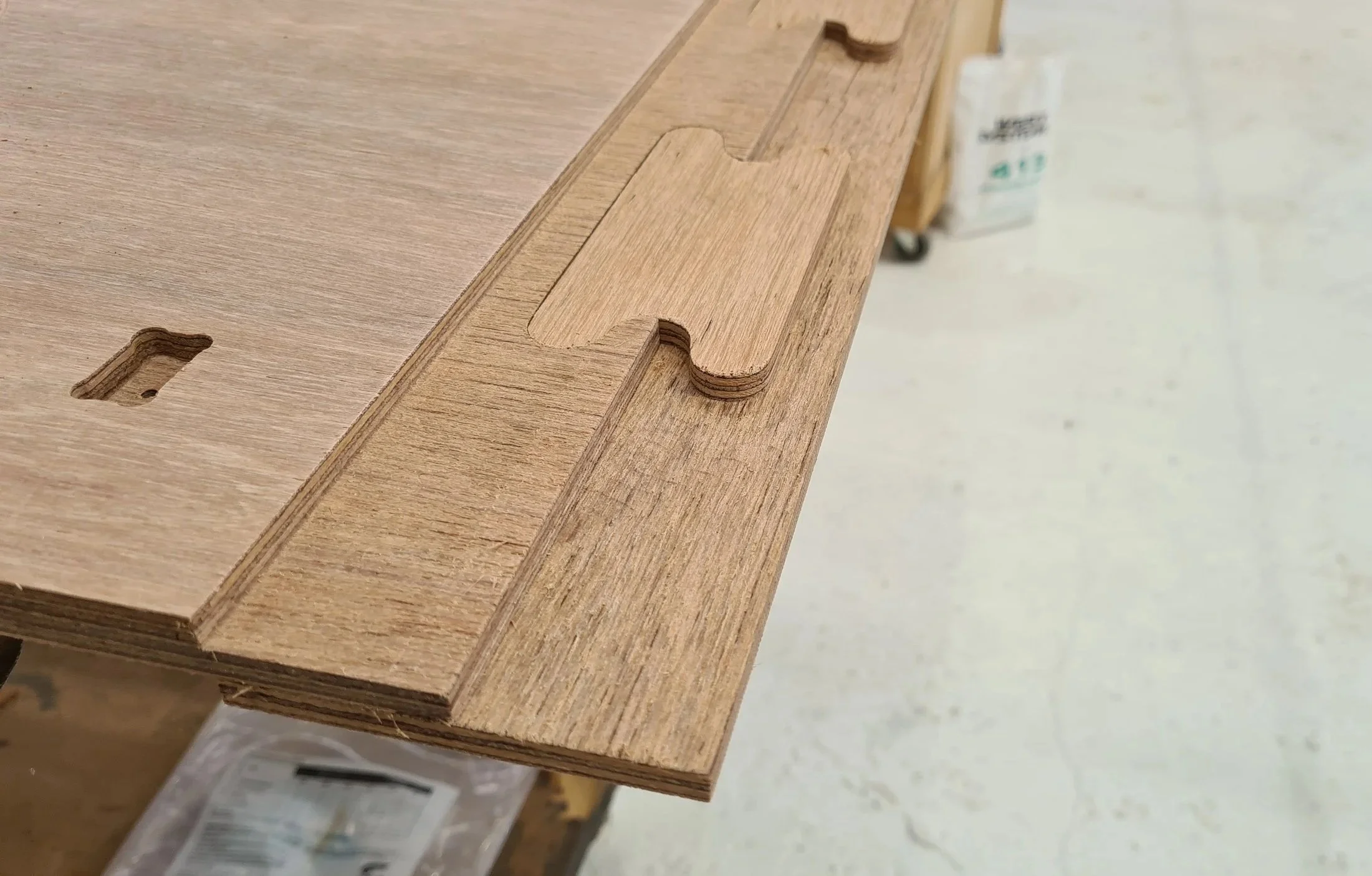 Close-up of a wooden table with a rectangular slot and a matching piece indicating a slot-in joint design.