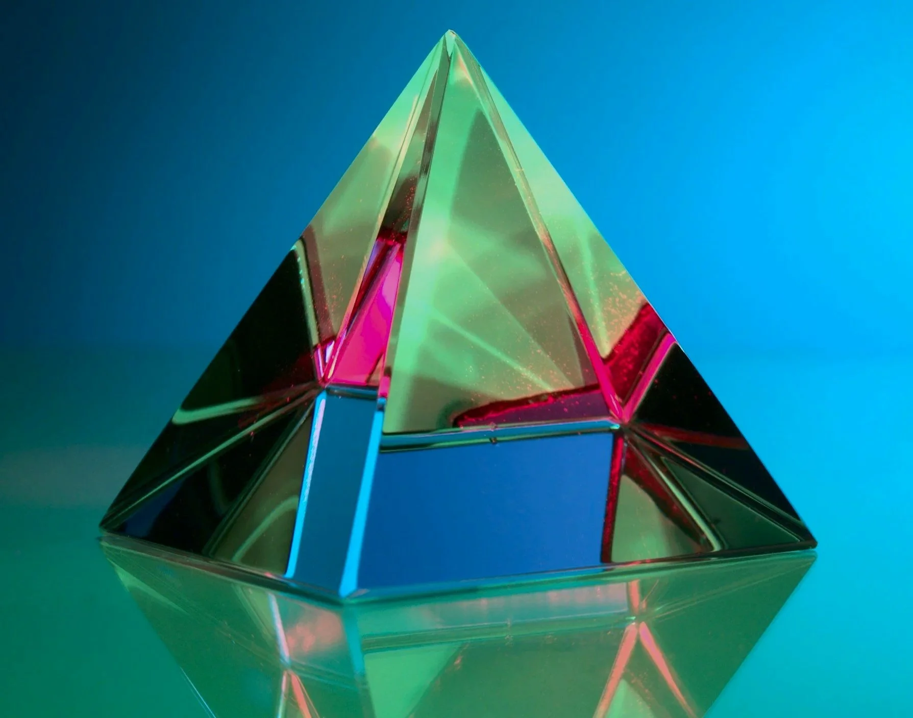 Modern house with wooden exterior and stone steps leading up to it, set against a hilly landscape with snow-capped mountains in the background.