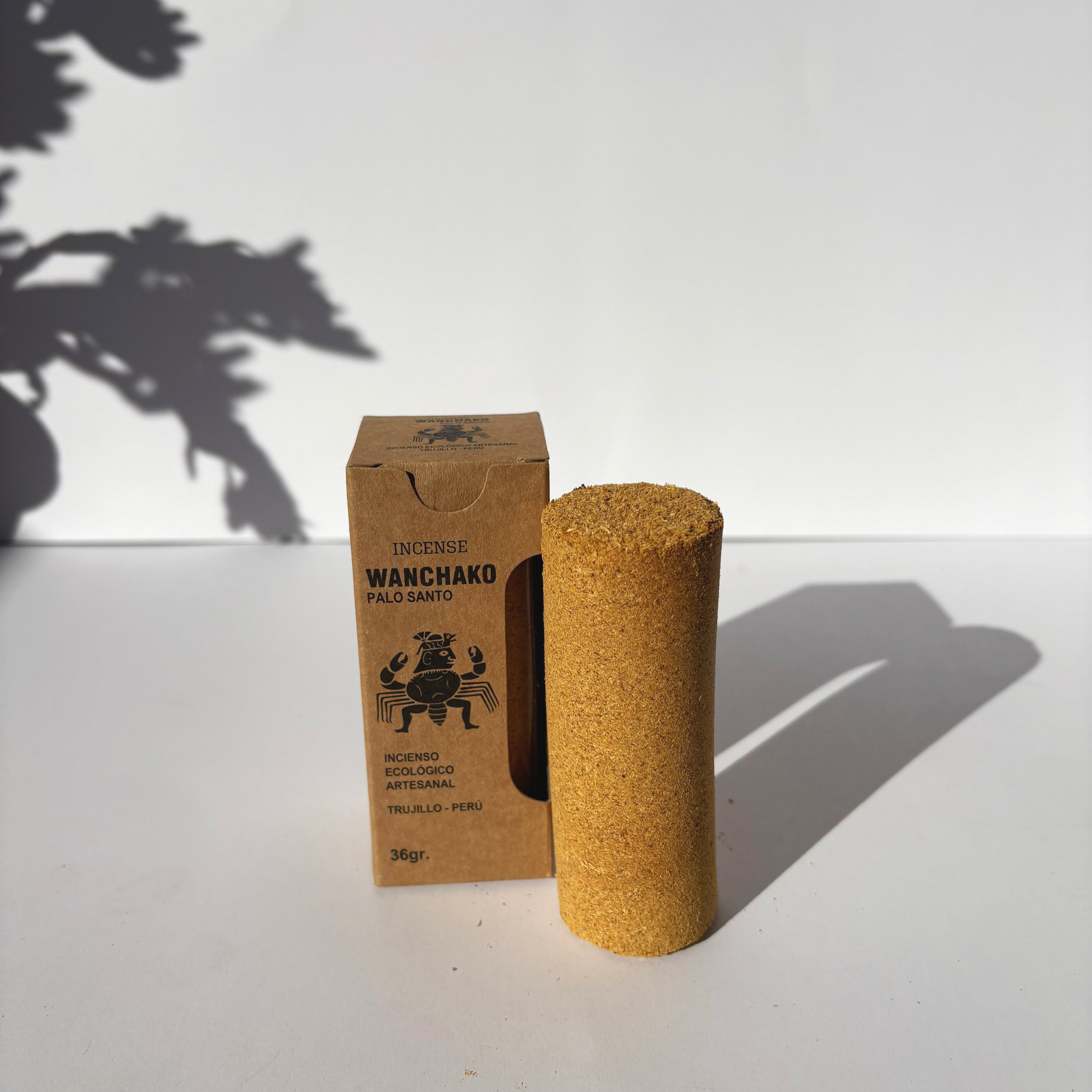 Upright Wanchako Palo Santo ceremonial stick beside its eco-friendly box, showing its full size and textured surface.