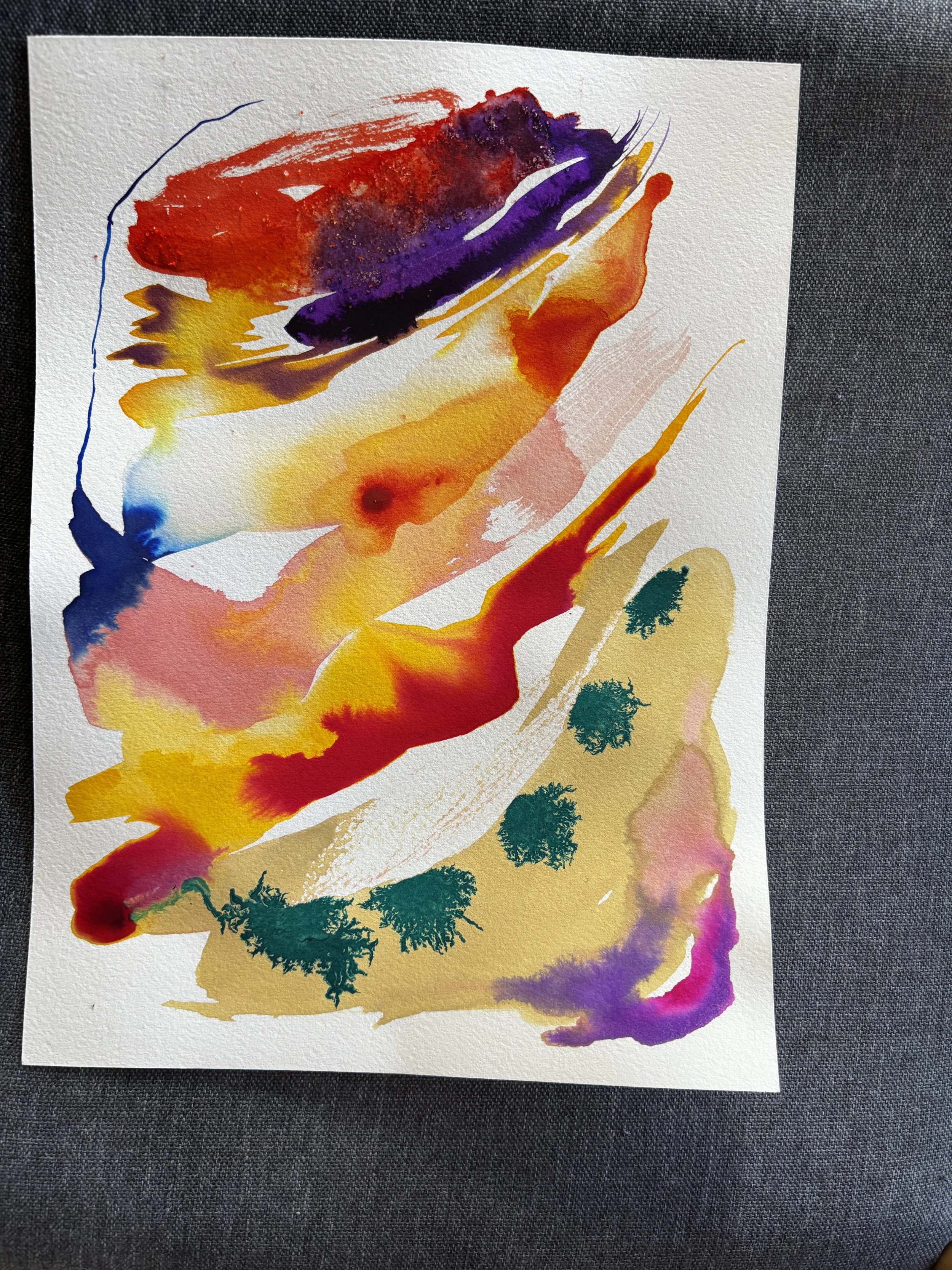 Colorful abstract watercolor painting on paper with various splashes of red, purple, yellow, blue, pink, and green.