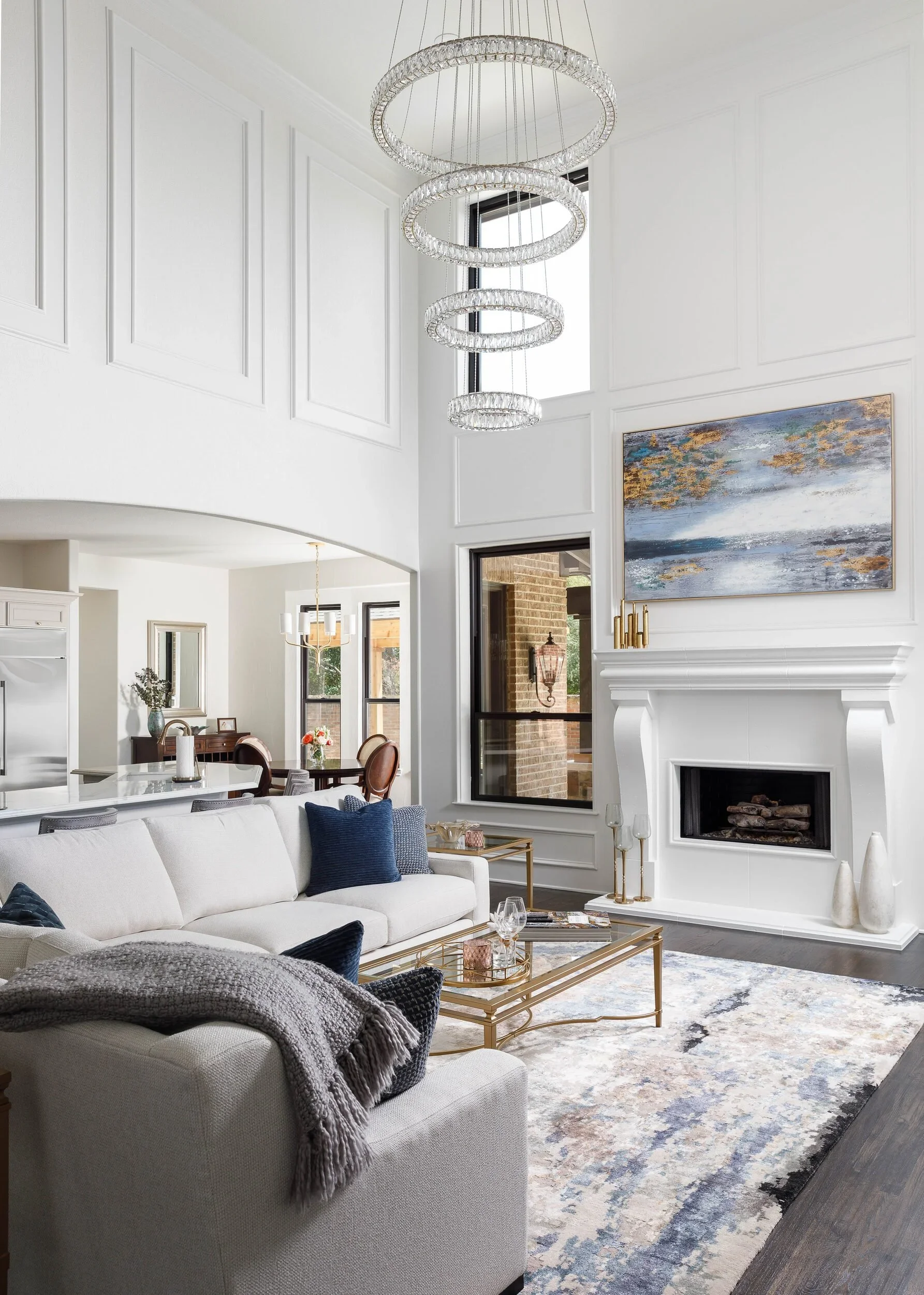 Two-story living room with white walls and tall windows, built by Agapé Home Services.