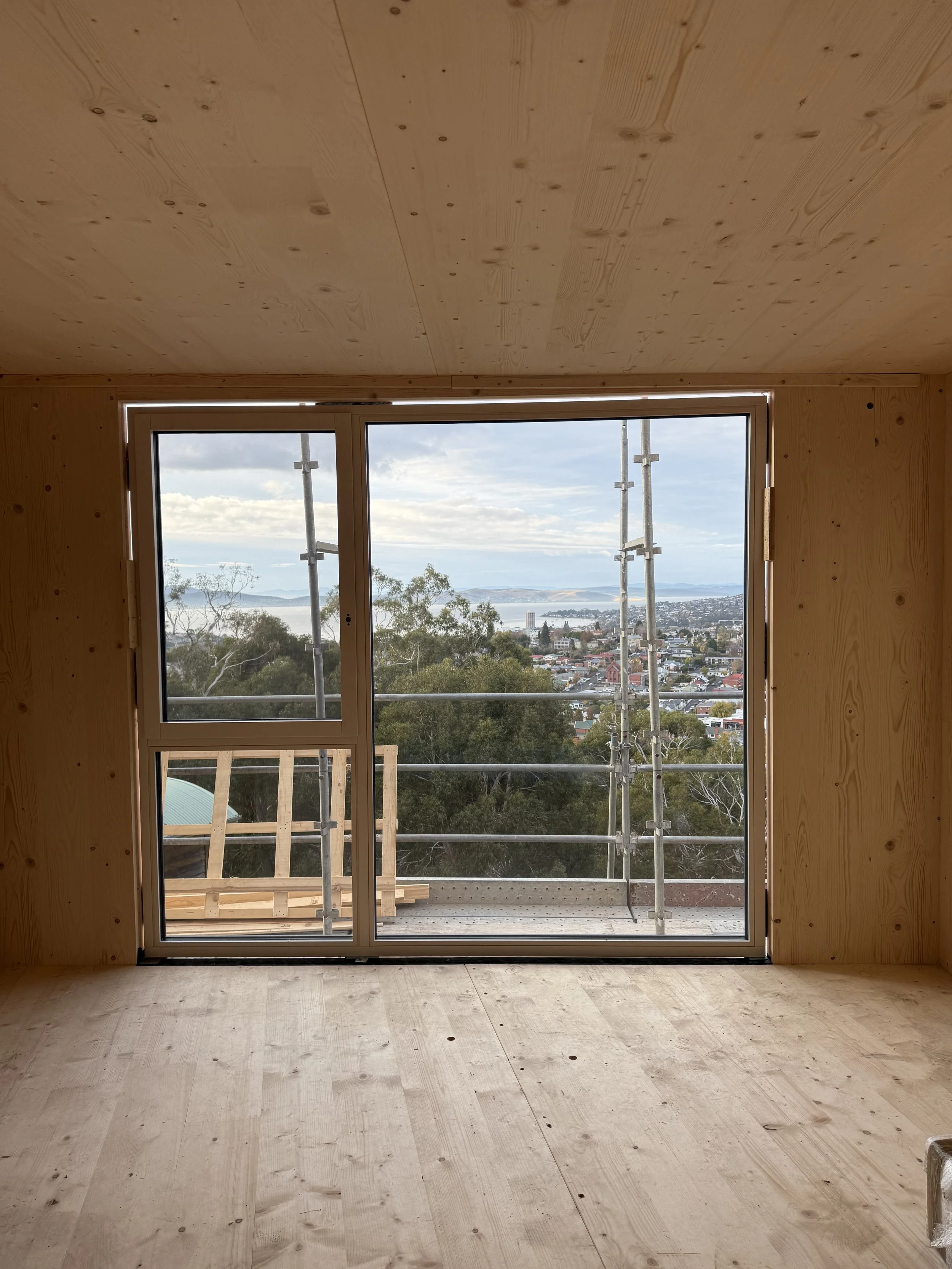 Hobart Hills CLT House. Site construction progress showing CLT mass timber and triple glazed windows by Loubser Workshop