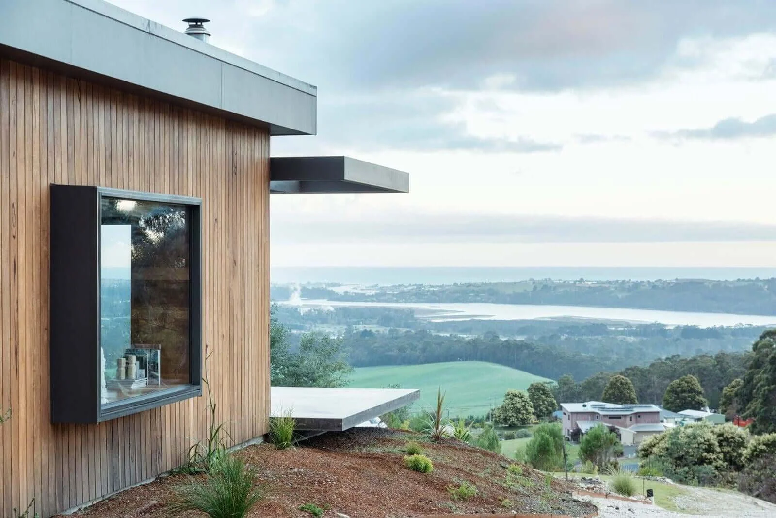Rural dream home facade timber shiplap cladding, boxed bay window and cantilevered deck in South Spreyton, Tasmania by Loubser Workshop