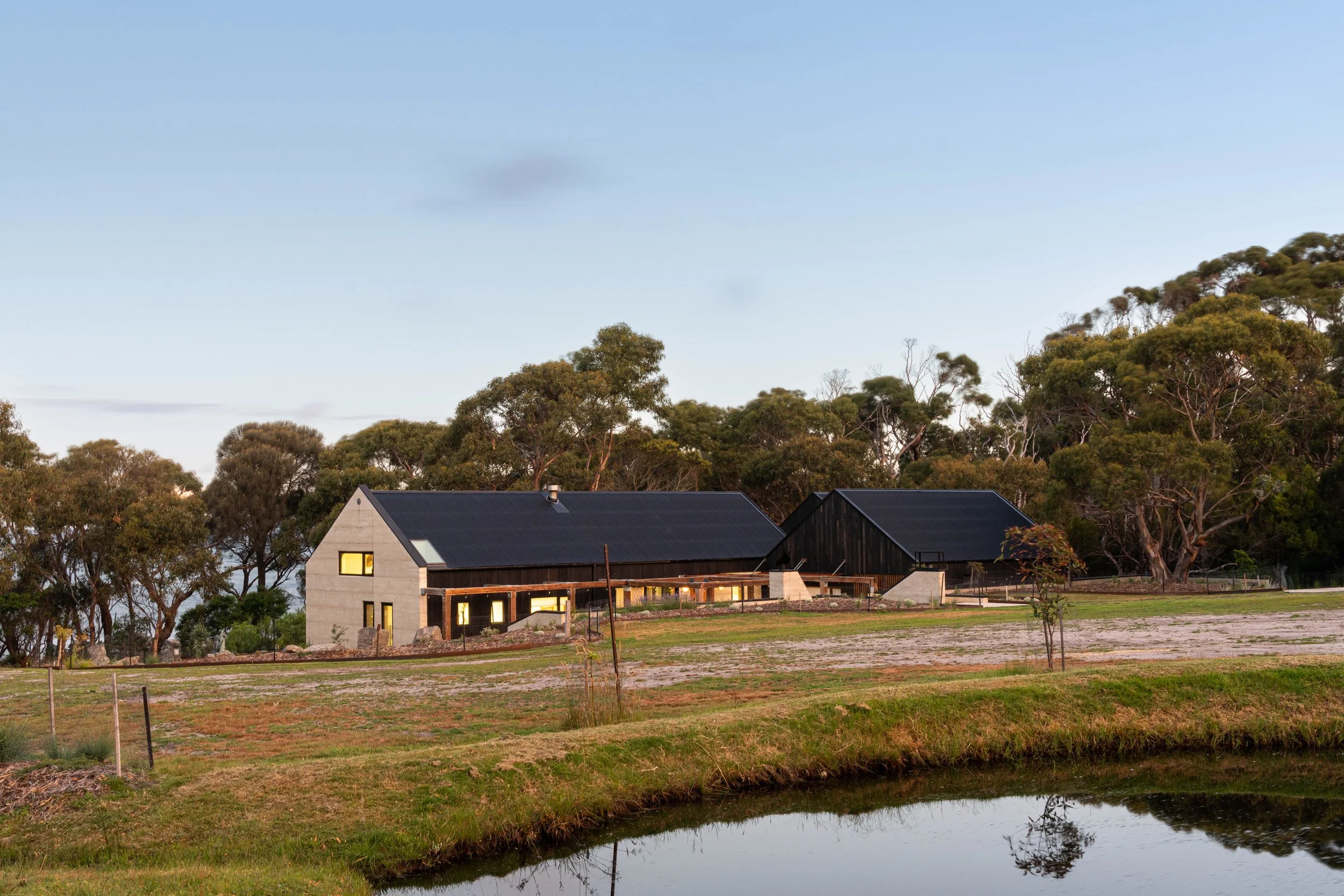 Rural dream home exterior with rammed earth, Shou Sugi Ban cladding and Colorbond Night Sky roof in Bicheno, Tasmania by Loubser Workshop