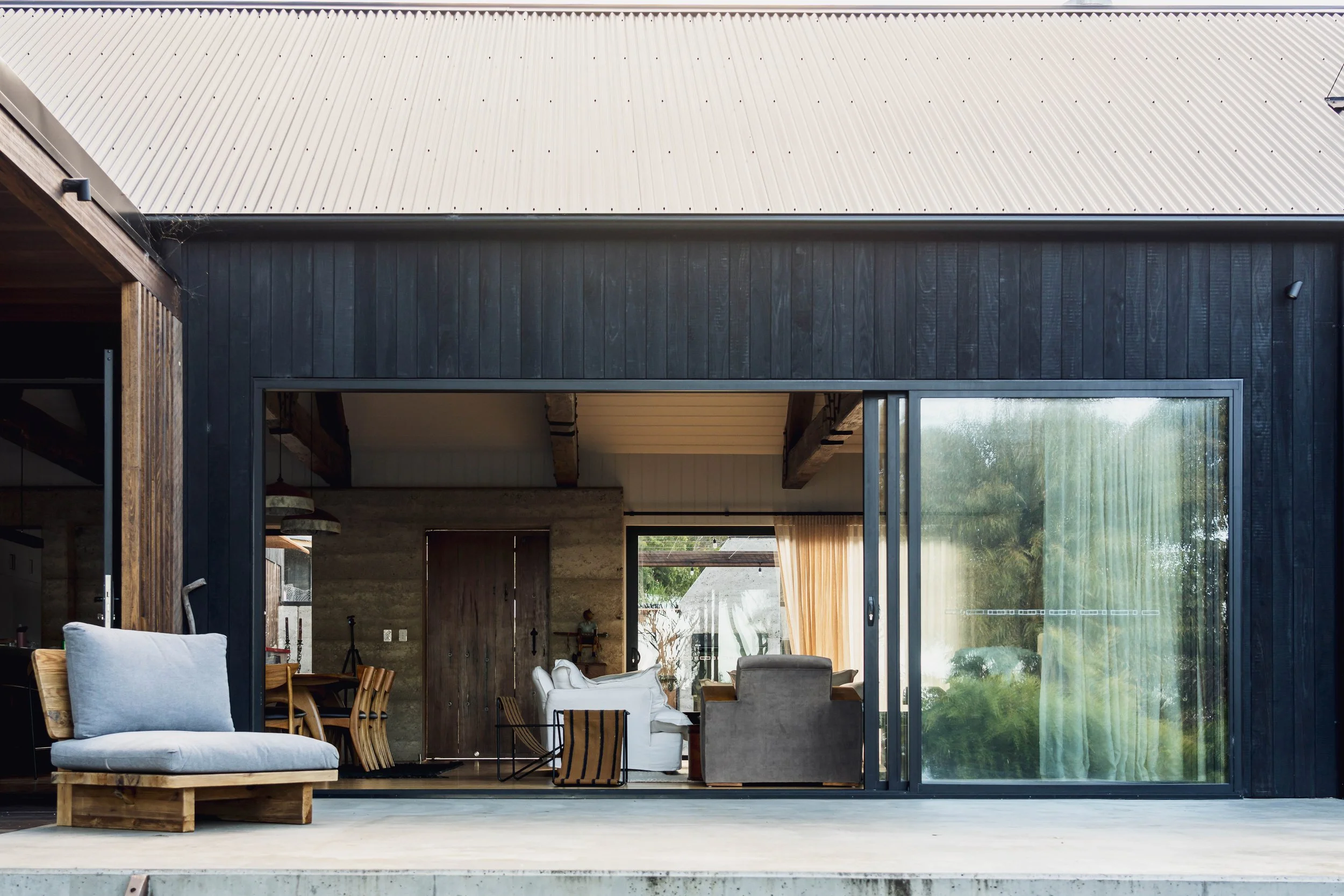 Bicheno Beach House indoor outdoor living with rammed earth, shou sugi ban timber in a rural coastal setting by architect Michael Loubser from Loubser Workshop in Tasmania