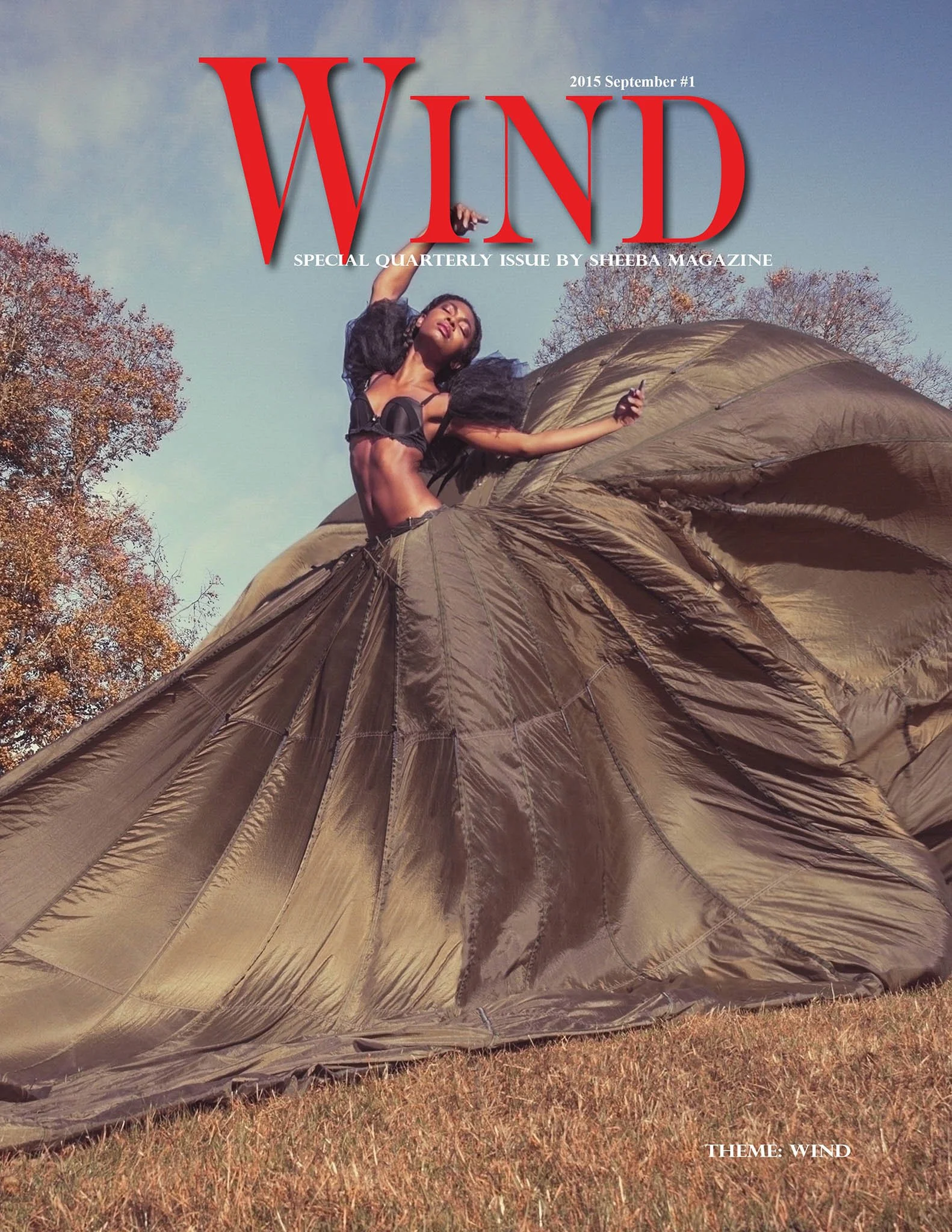 Cover of Wind magazine featuring a woman standing on a large, flowing windmill or kite-like fabric outdoors during autumn, with trees in the background and a blue sky.