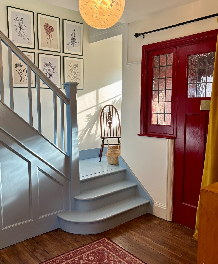 Hallway with blue stairs and red door