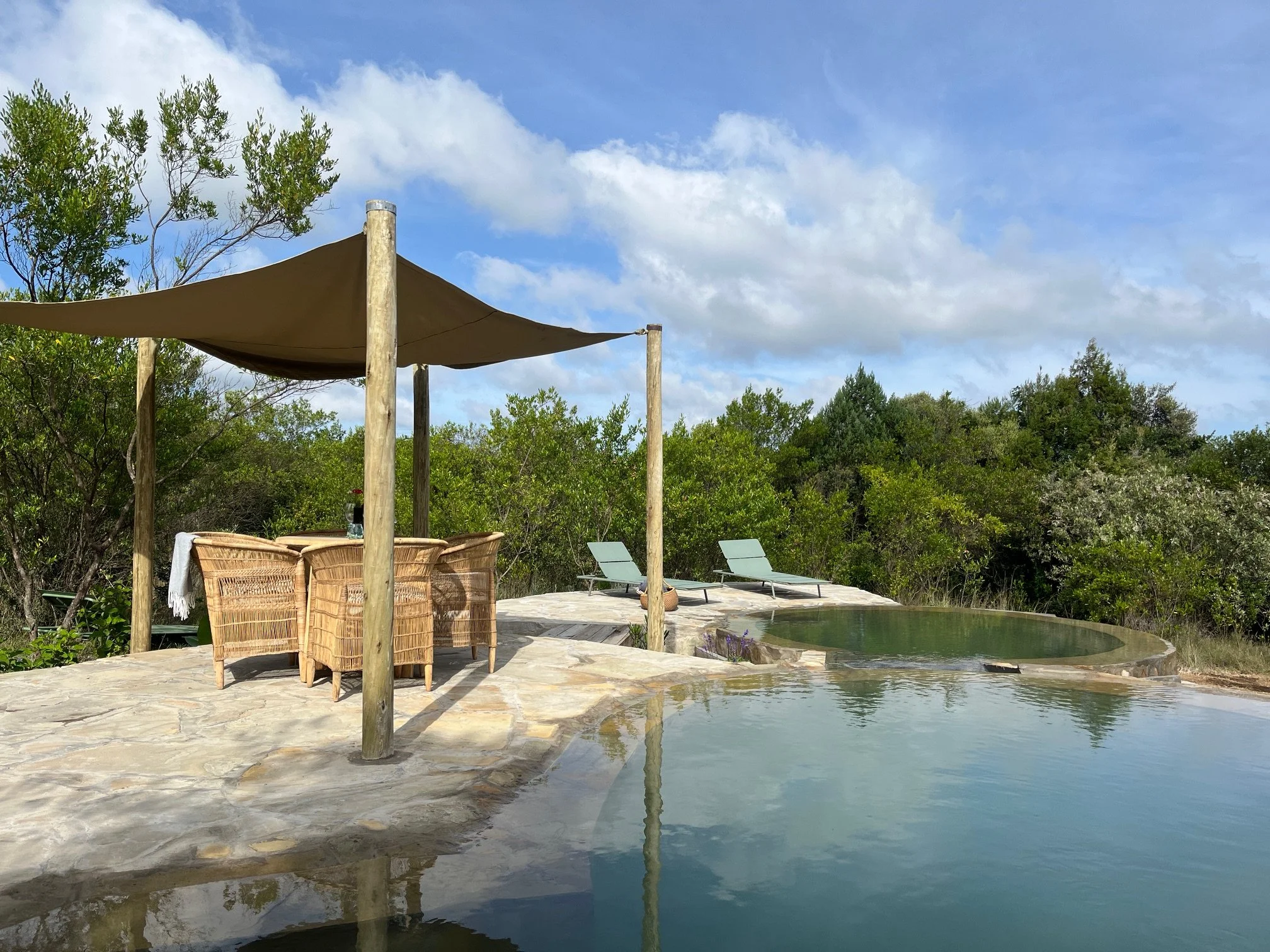 Shared swimming pool with sunbeds and eating area