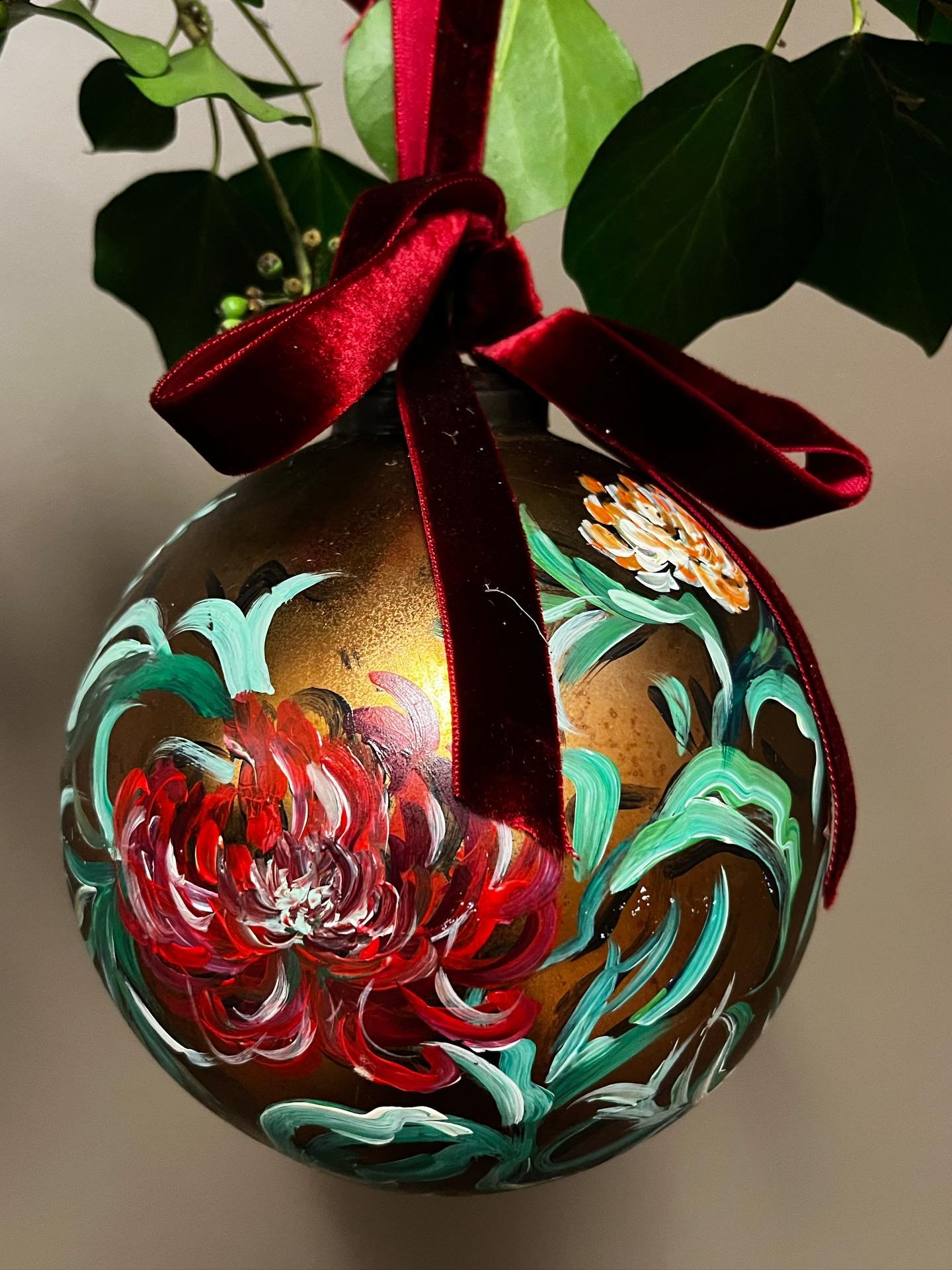 Festive Floral Bauble - Garnet 
.
This recycled gold glass bauble is carefully hand-painted by Claire, featuring layered florals that give each piece its own unique charm. 
.
Finished with a rich red velvet bow, it brings a touch of luxury to your Ch