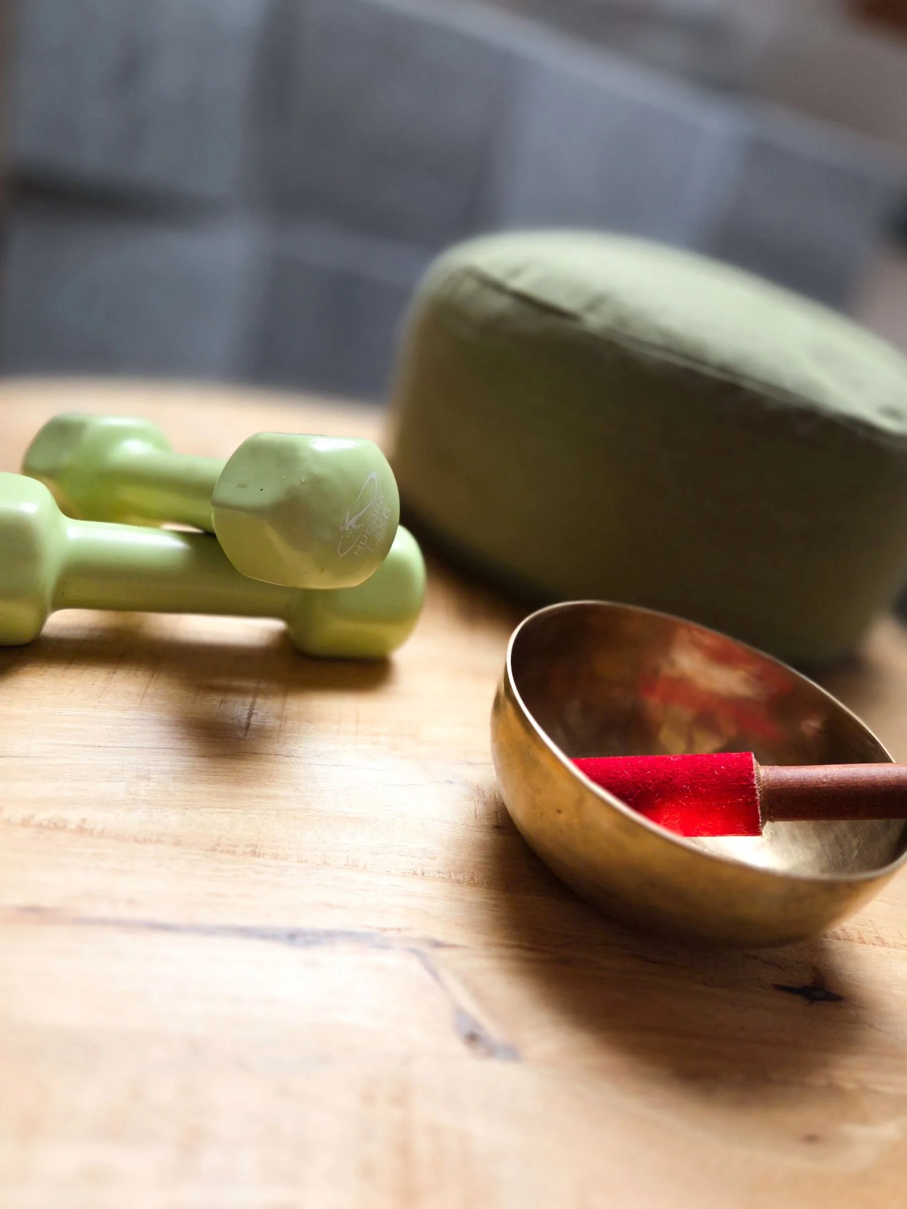 Klangschale, Hanteln und Meditationskissen als Symbole für Methoden zur Nervensystemregulation bei Erschöpfung