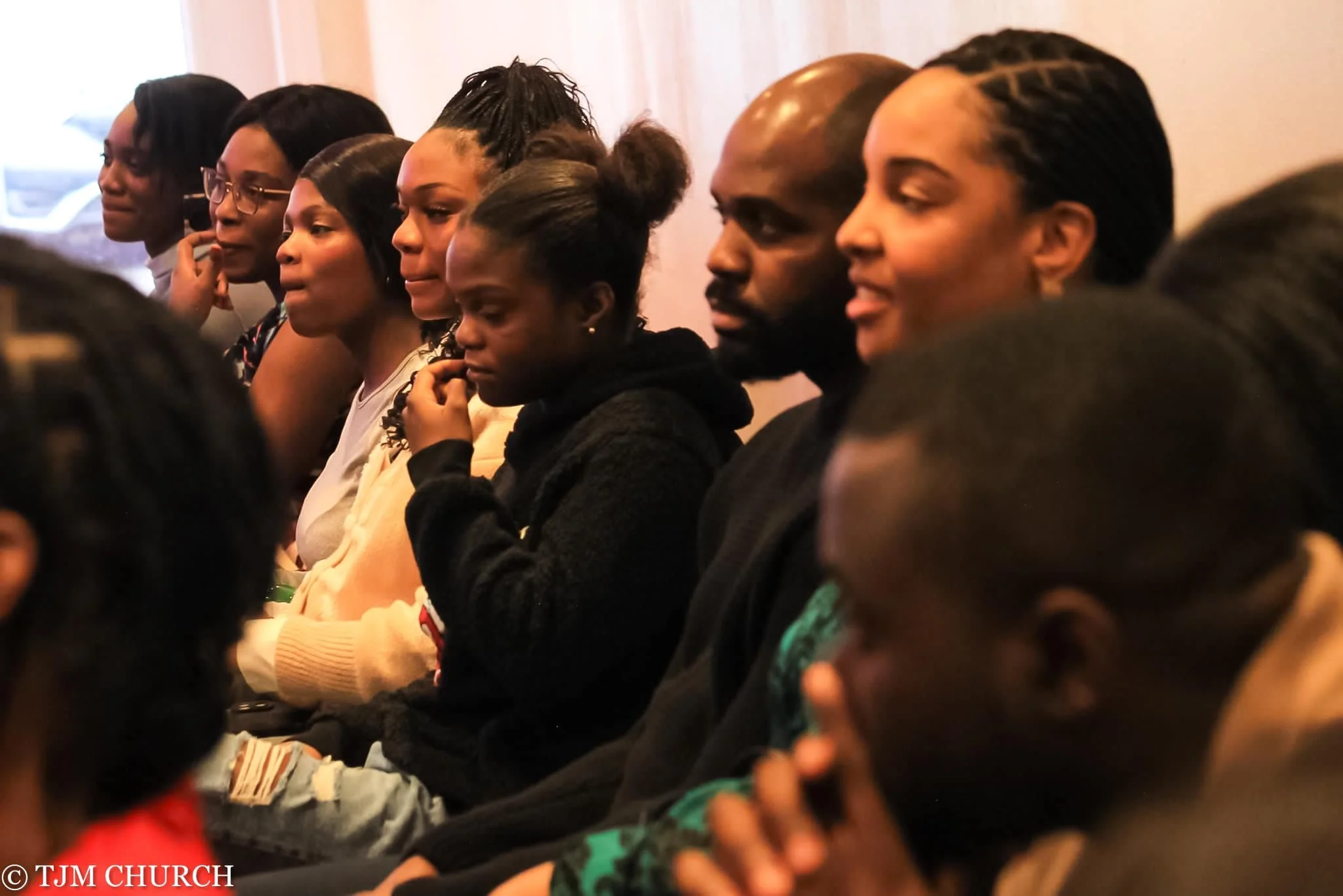 Group of diverse people seated and paying attention at an indoor event
