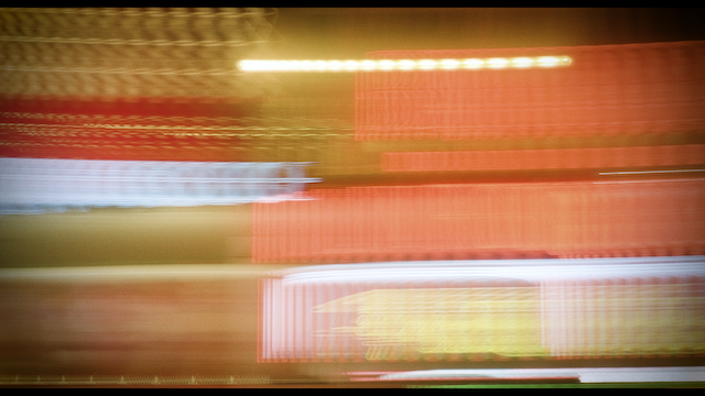A motion-blurred image of a cityscape at night, capturing the essence of speed and urban life with streaks of light and vibrant colors.