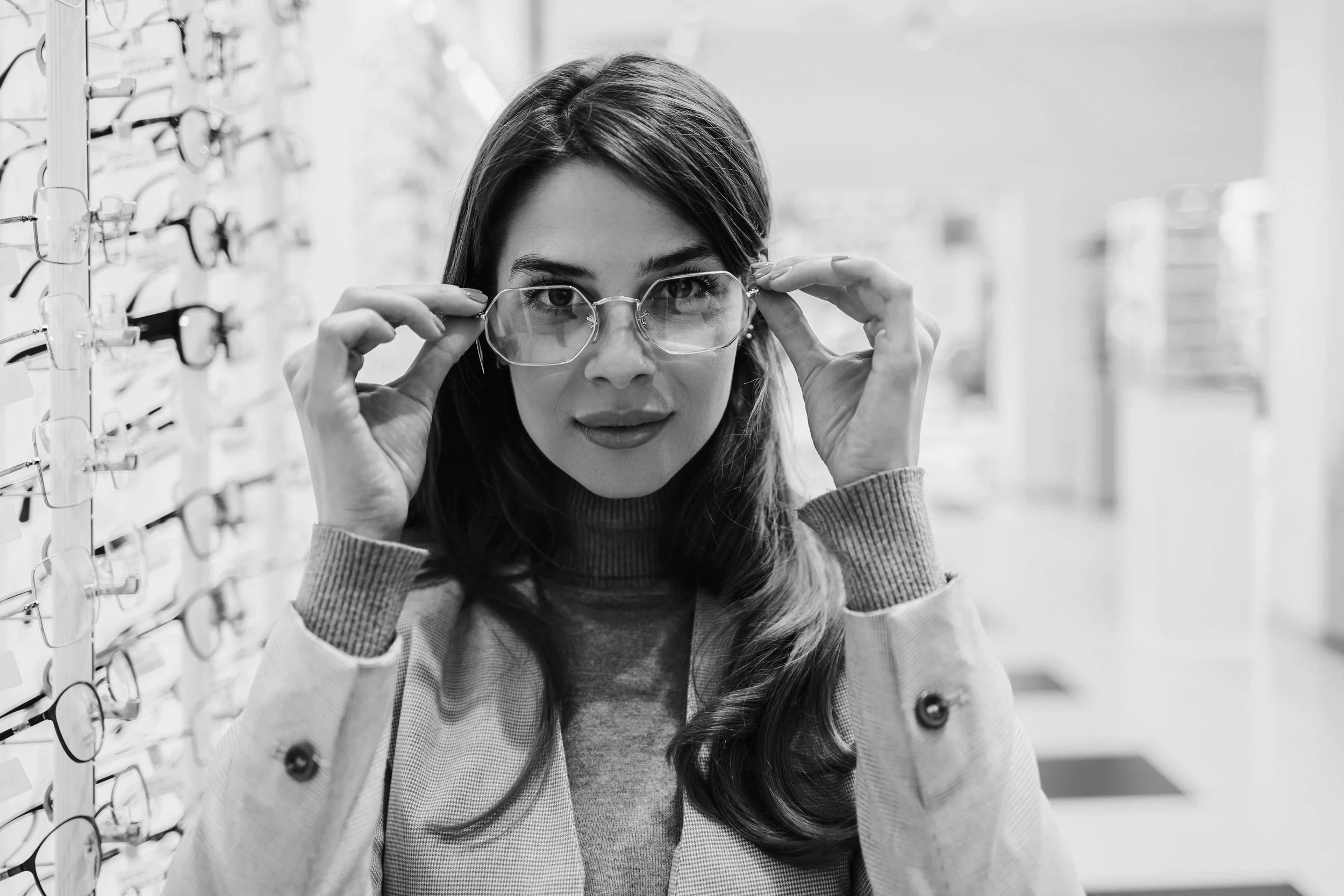 Woman trying on a pair of glasses and looking fiercly into the camera.
