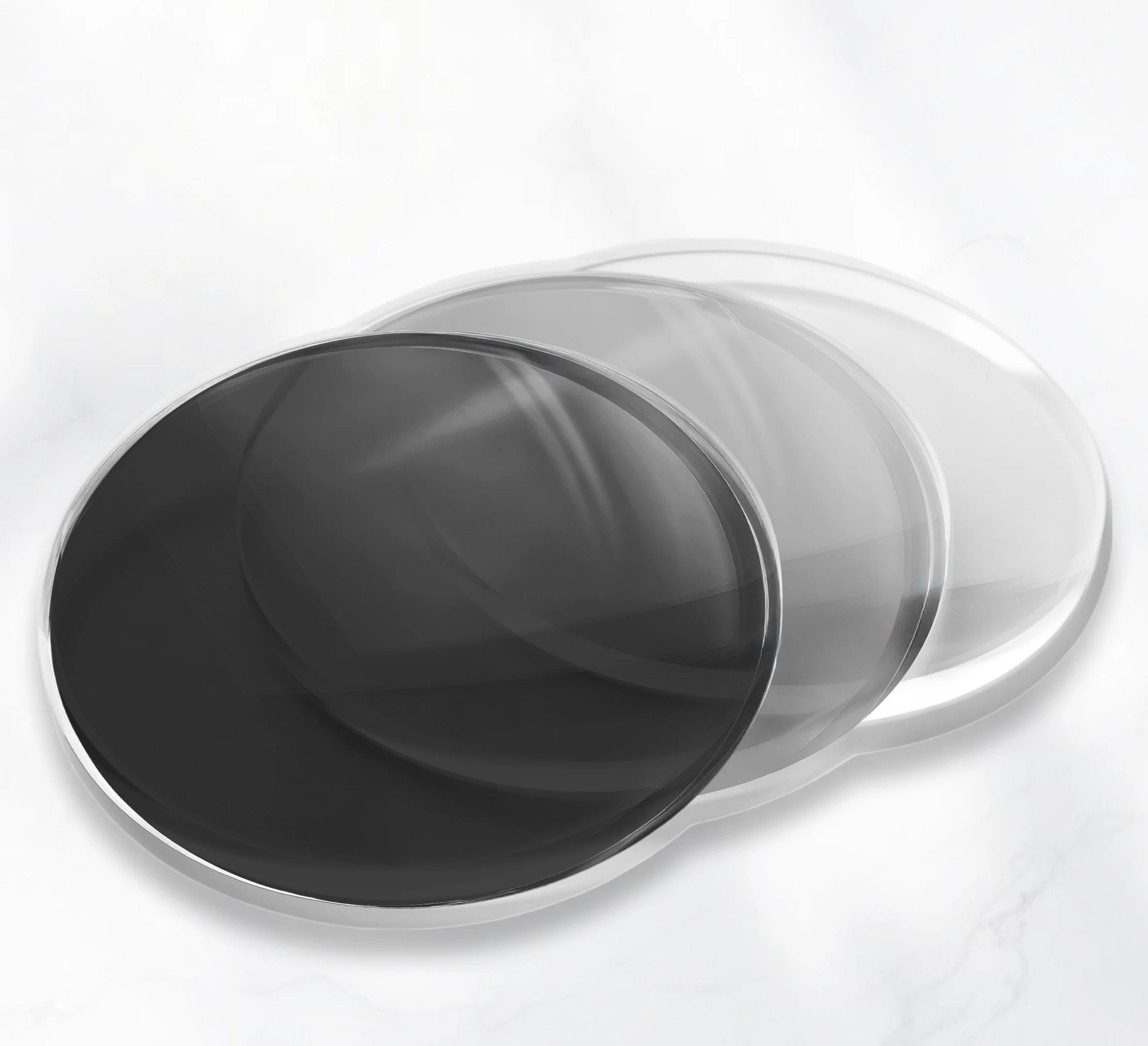 Close-up of black sunglasses with dark tinted lenses and metal frame on a light surface.
