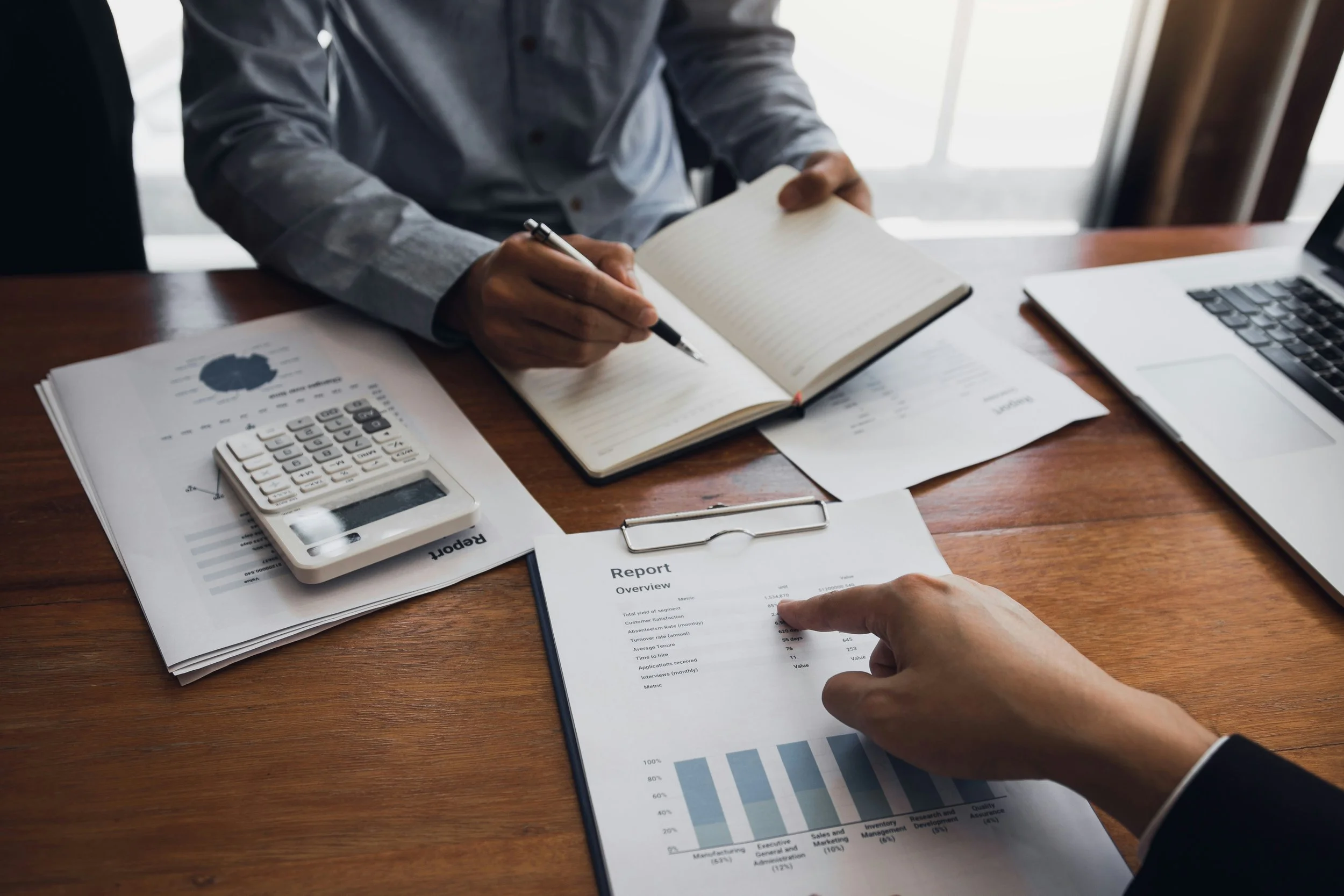 Business operations between two people, only arms and documents visible.