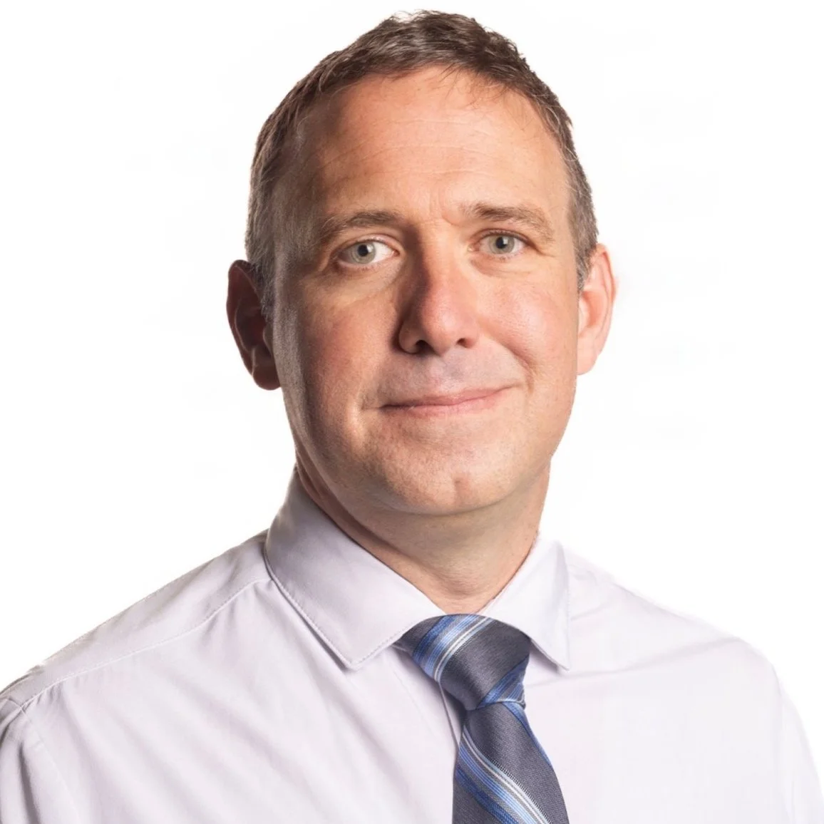 Man in white shirt with blue striped tie, smiling