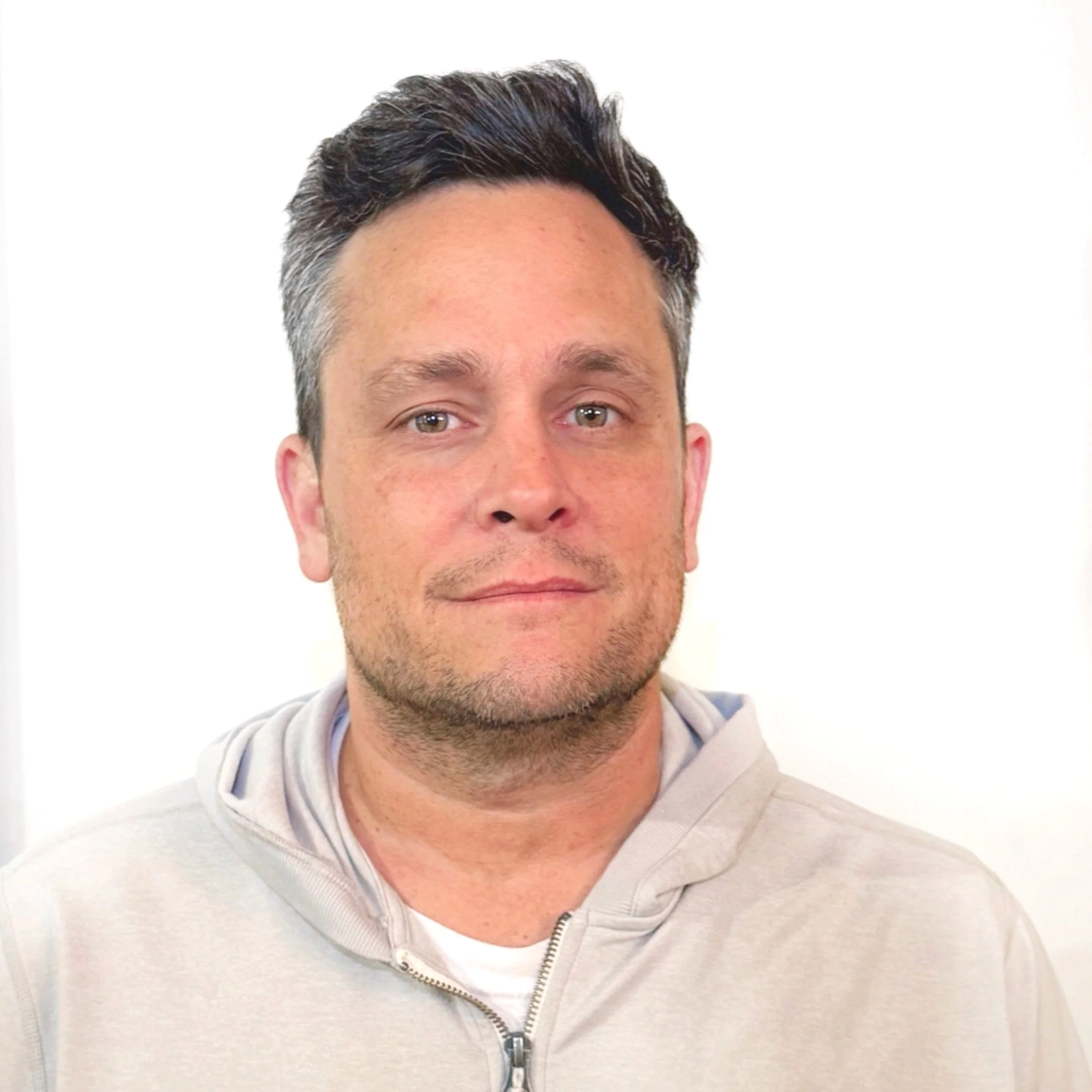 Man wearing a light gray hoodie against white background