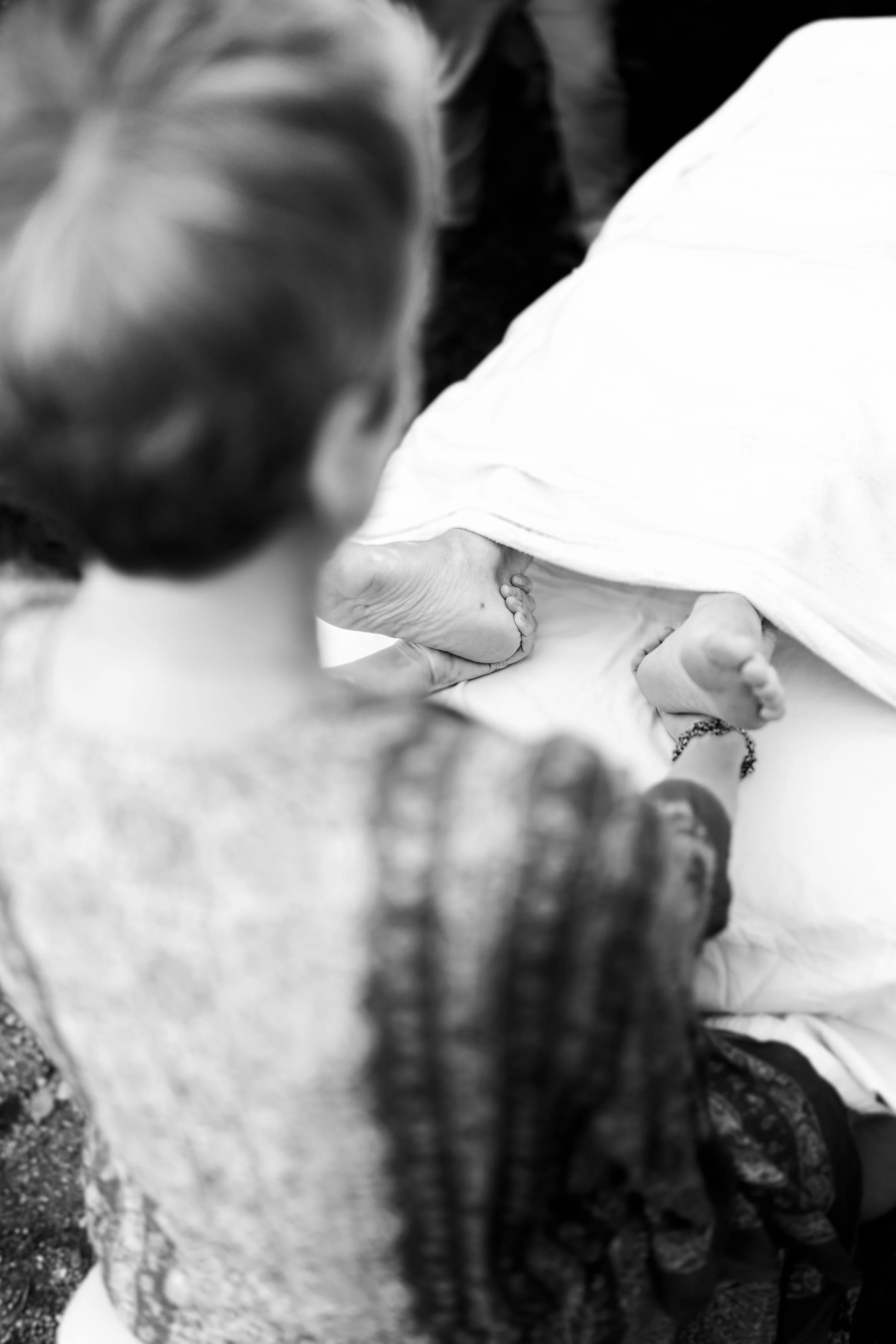 A black and white photo showing two children playing on the ground, with one child in the foreground and the other in the background, both engaged in an outdoor activity.