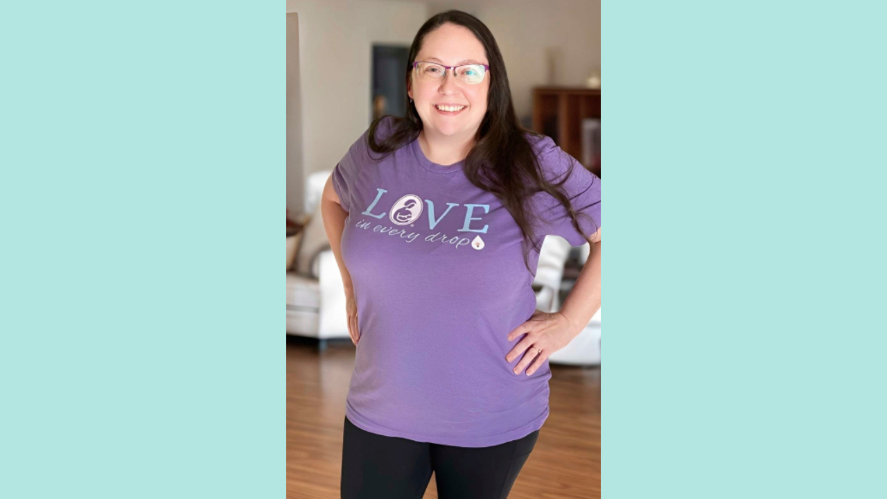 Image of a woman wearing the "love in every drop" t-shirt from the store. The shirt is purple with light green writing.