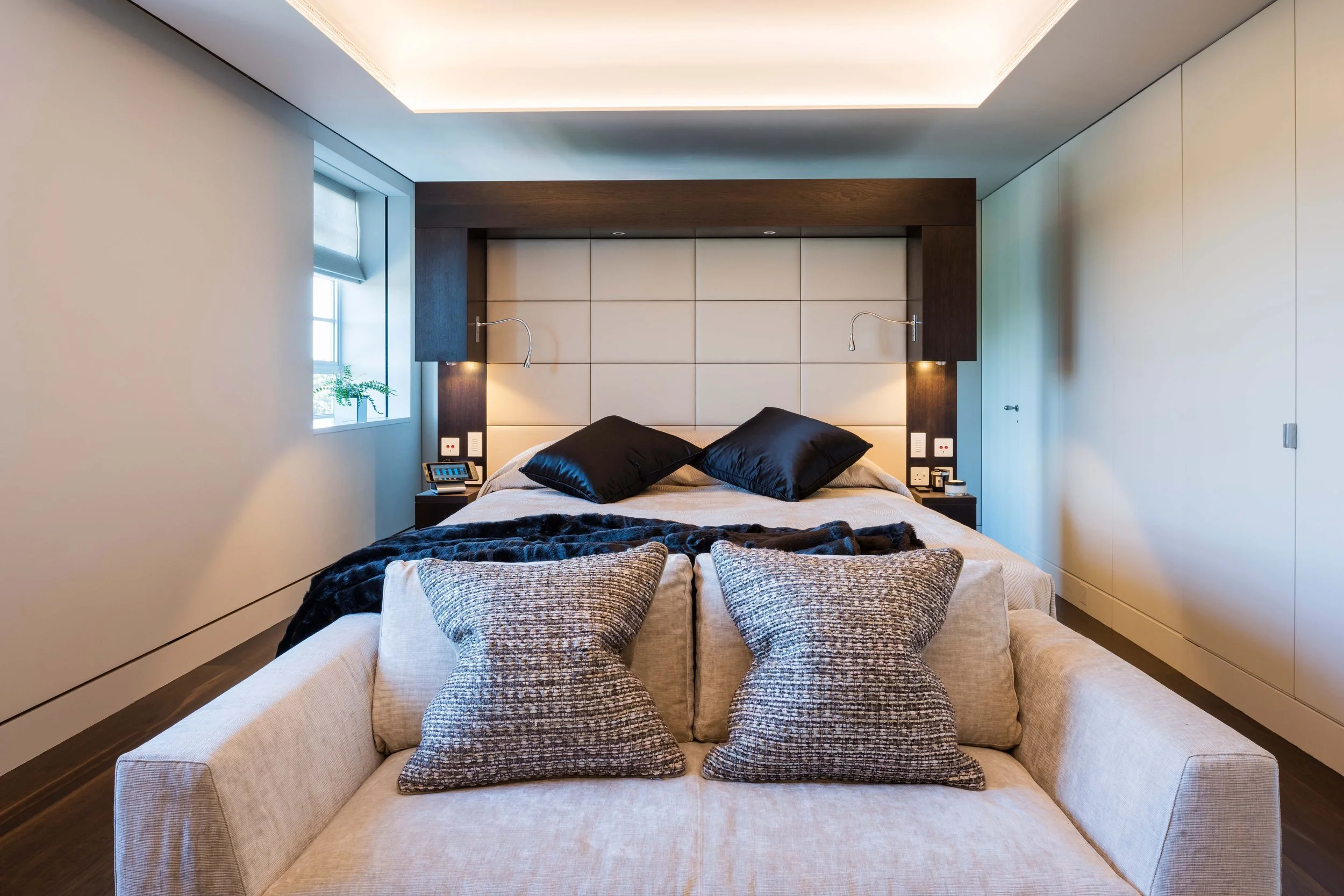 Elegant bedroom featuring a bespoke bed frame with built in electrical sockets and lighting by NBJ