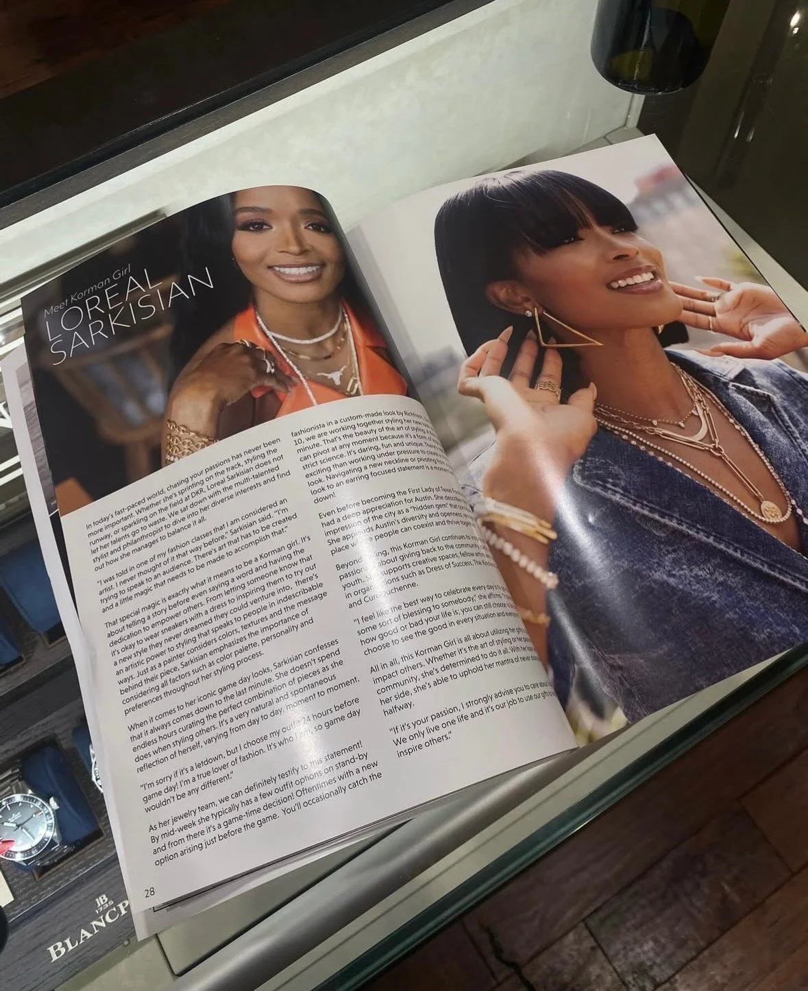 An open magazine showing a feature article about L'Oréal Sarkisian with two photos of a woman with dark hair, wearing layered necklaces, earrings, and jewelry, smiling and posing outdoors.