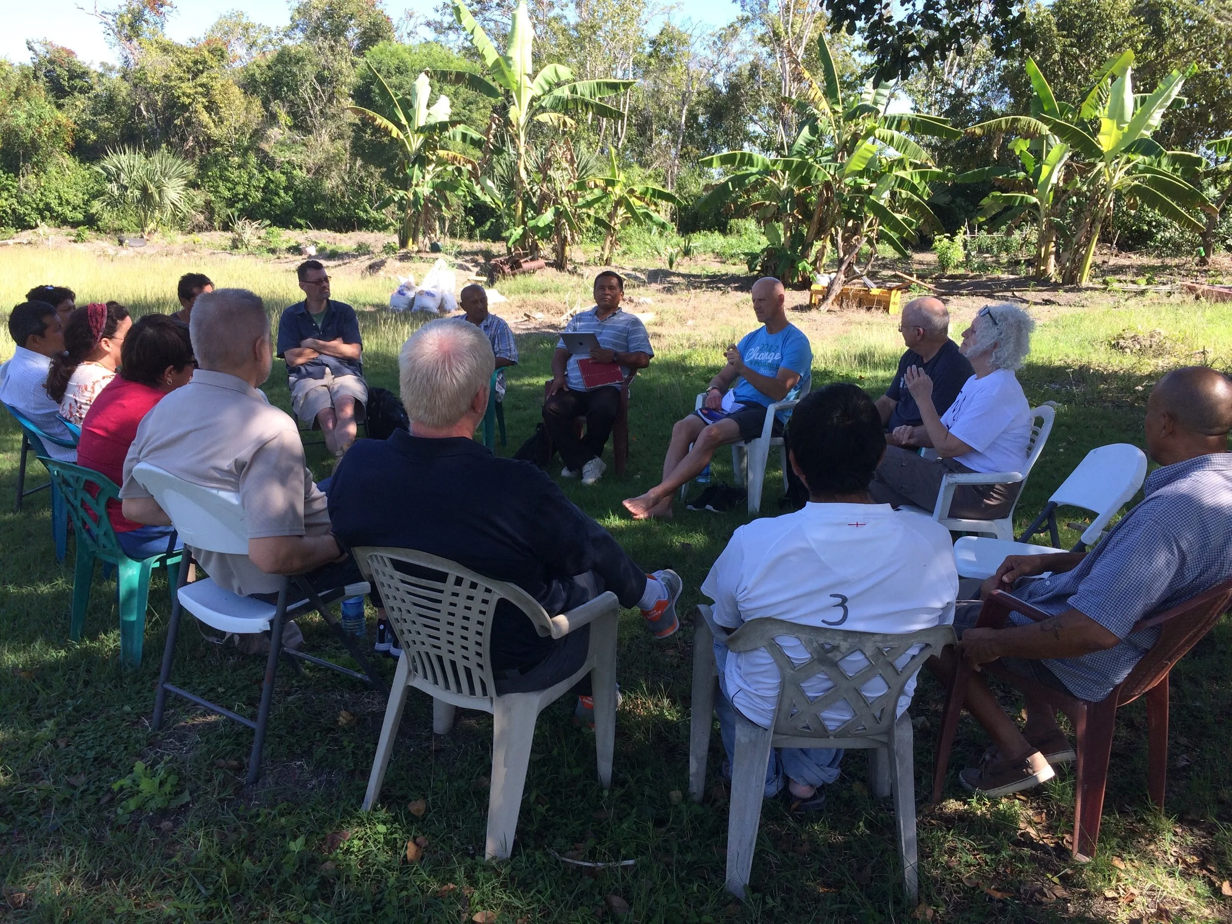 Empty black chair in a photography studio with a black backdrop, overhead lighting, and audio recording equipment.