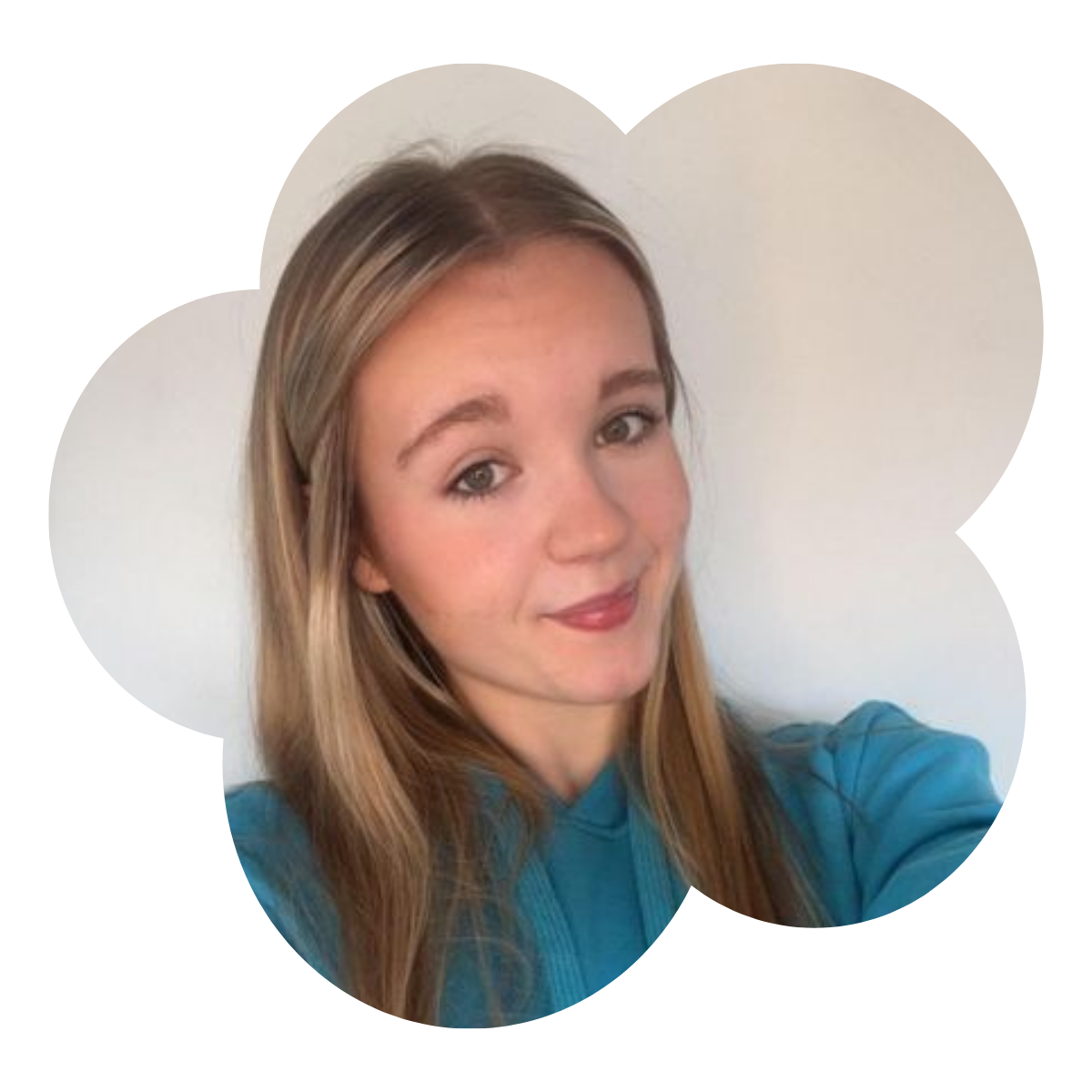 Young woman taking a selfie indoors, wearing a blue hoodie, with straight blonde hair and a slight smile.