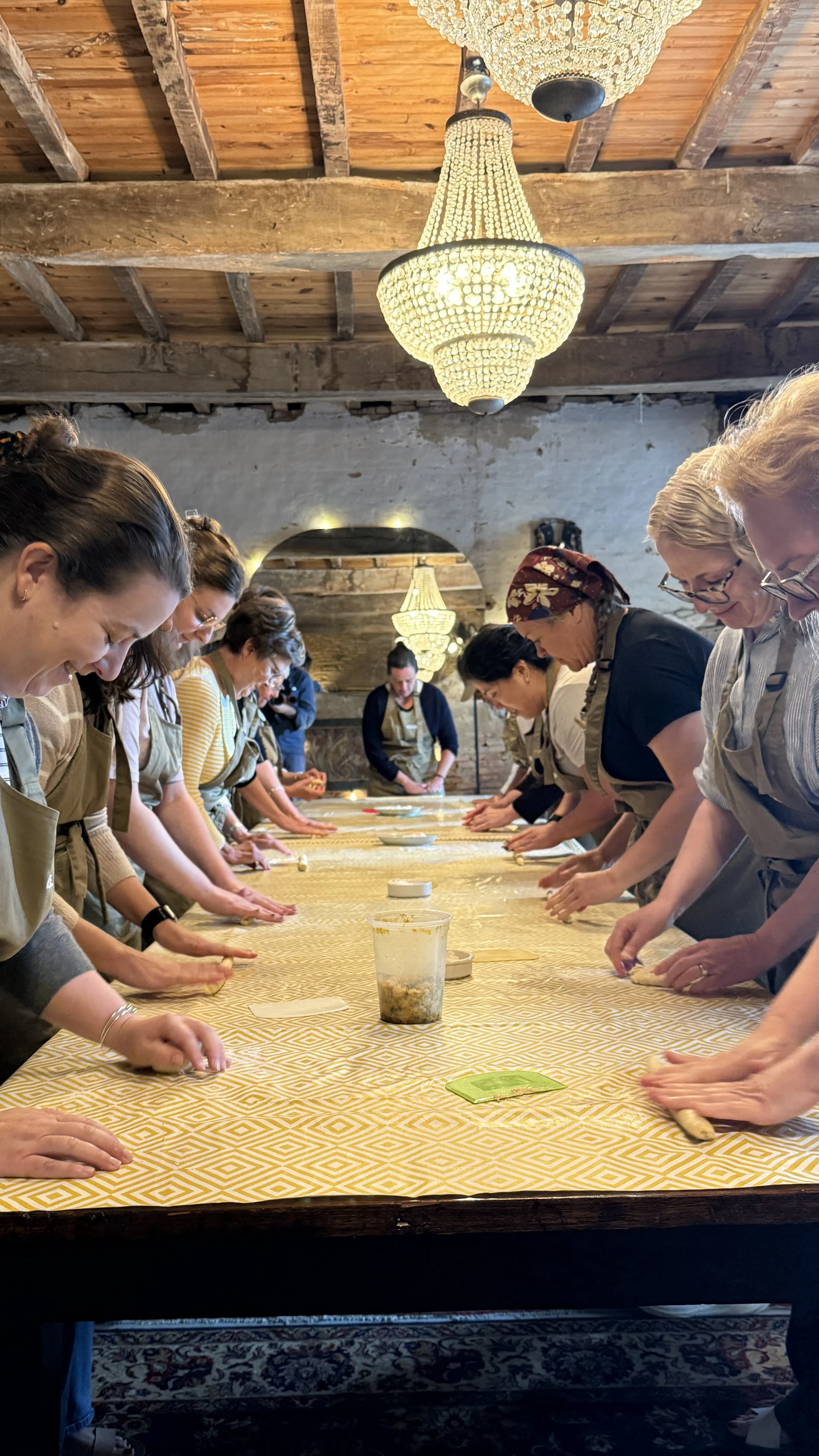 A group of bakers working with dough around a communal table.