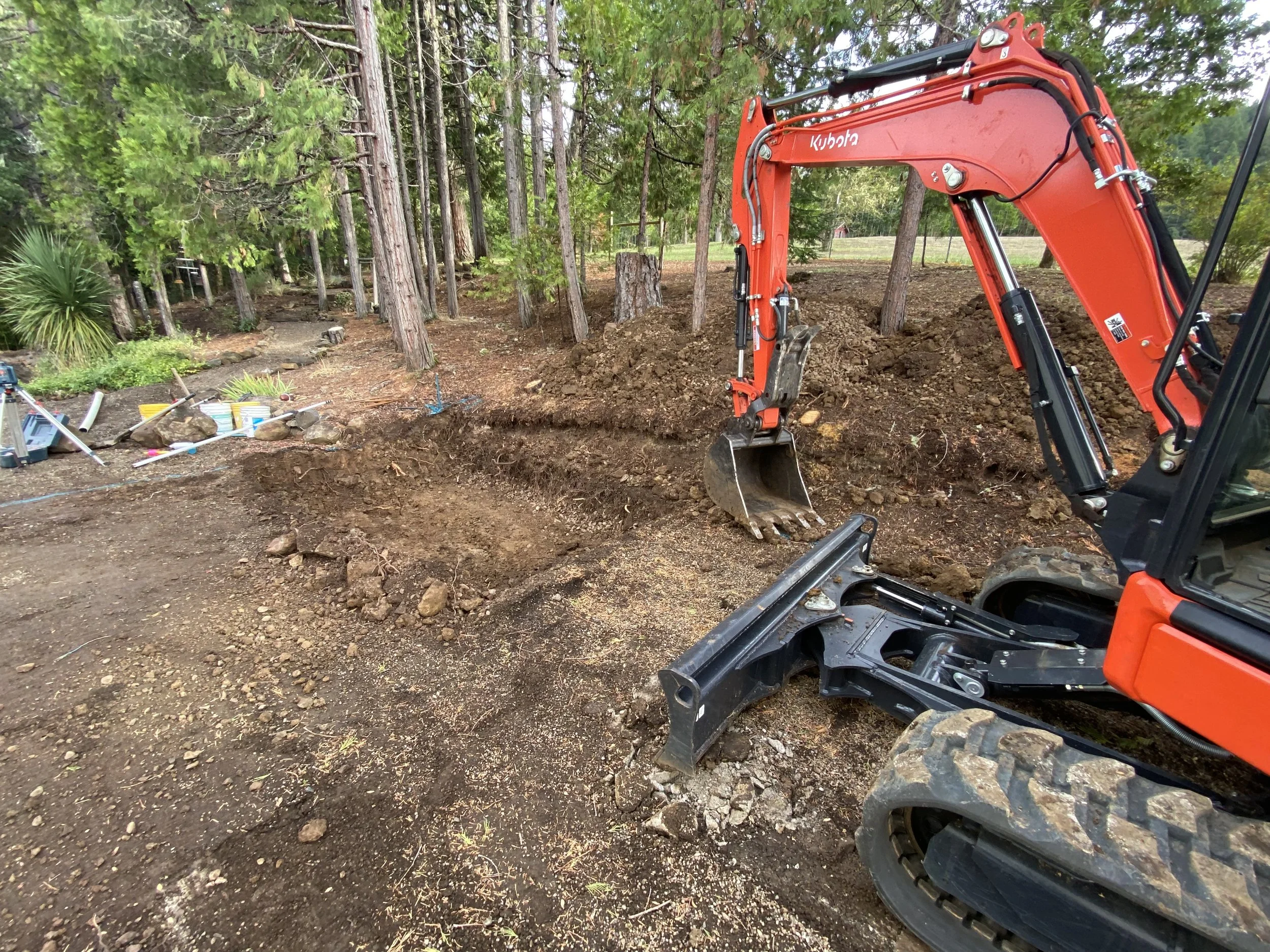 Removed approximately 100 cubic yards of material to establish a stable base for a future concrete slab while improving site drainage.