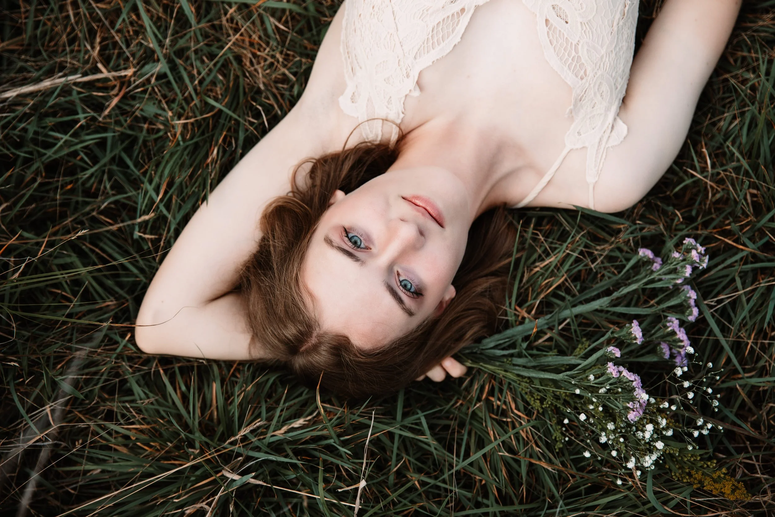 girl with blue eyes laying down in a field