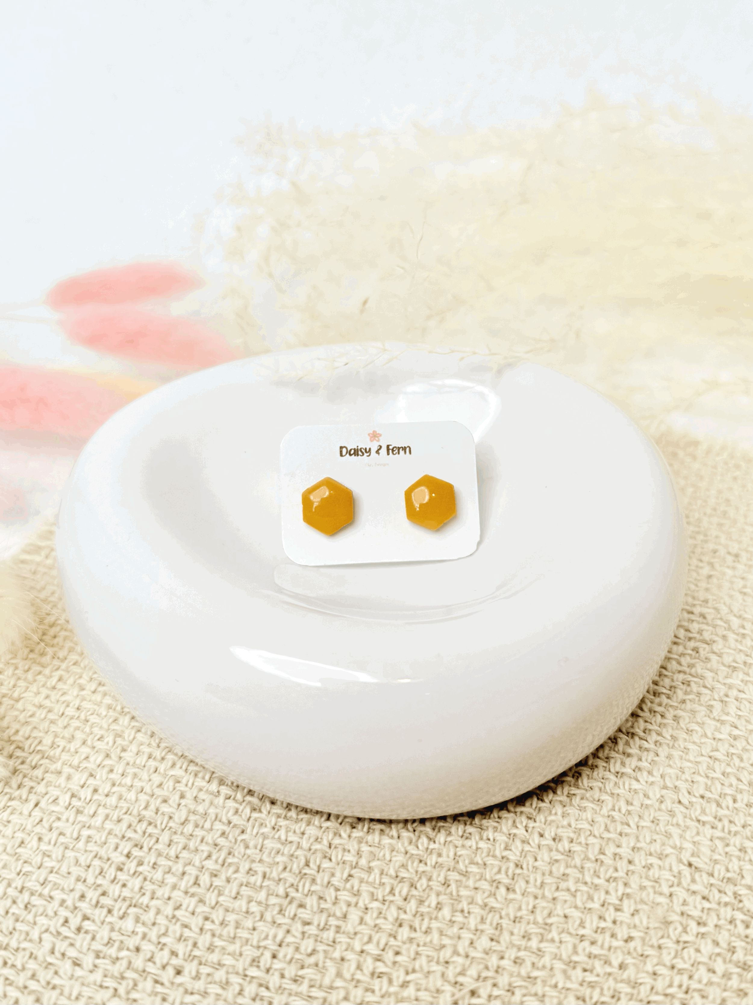 sunflower yellow hexagon stud earrings on jewellery dish with dried flowers decoration