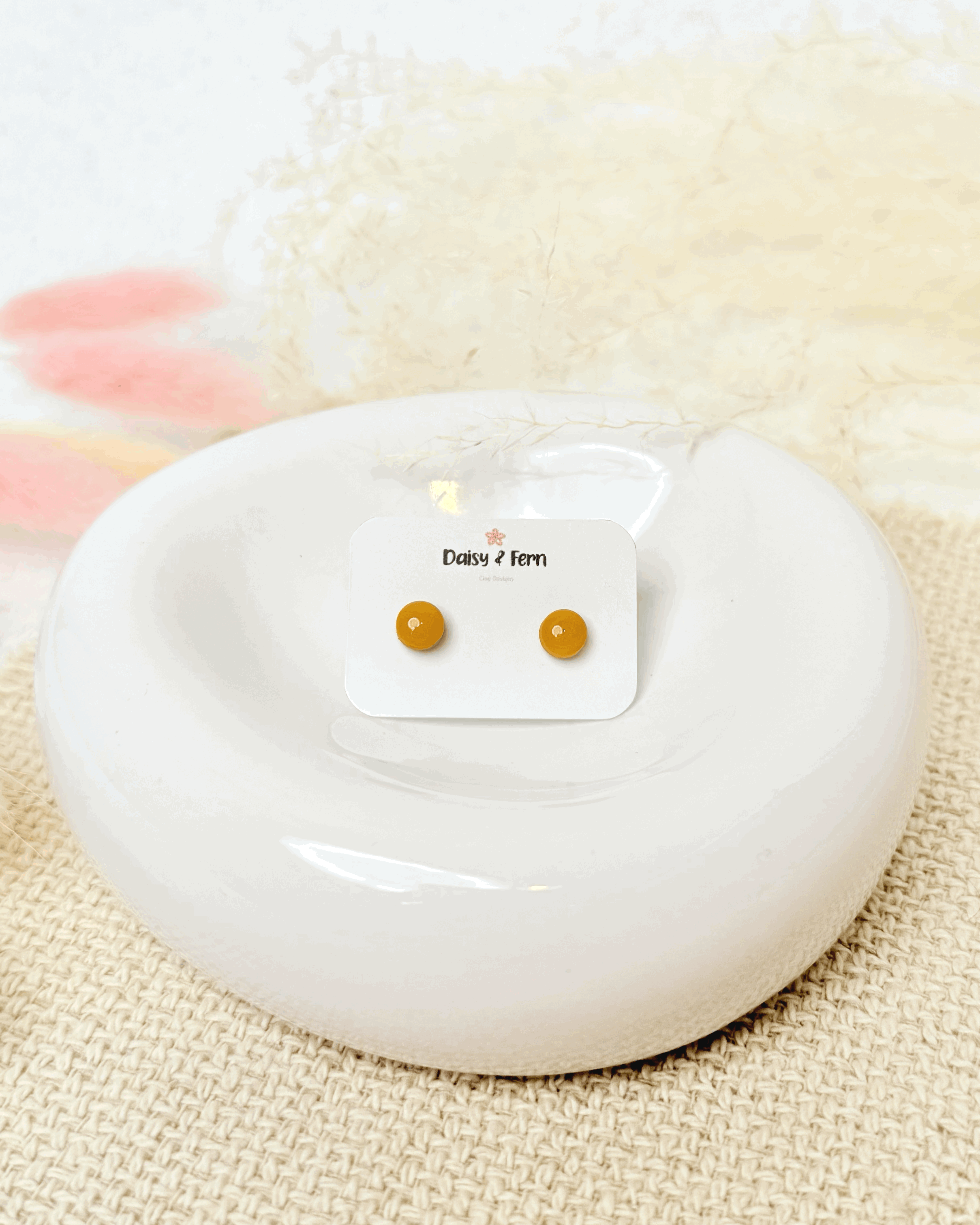 sunflower yellow circle stud earrings on jewellery dish with dried flowers decoration