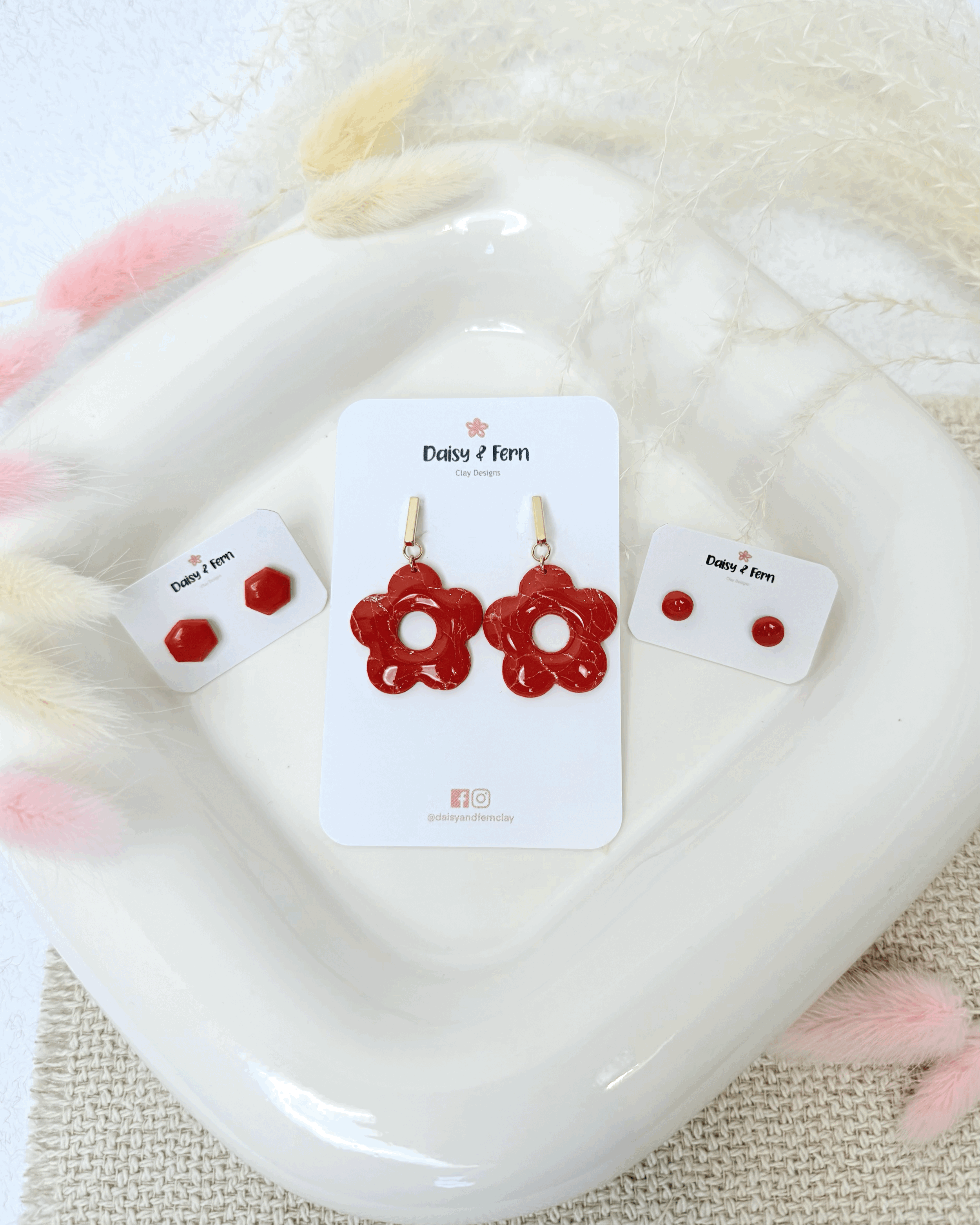 donut earrings and studs on white jewellery tray with dried flower decorations