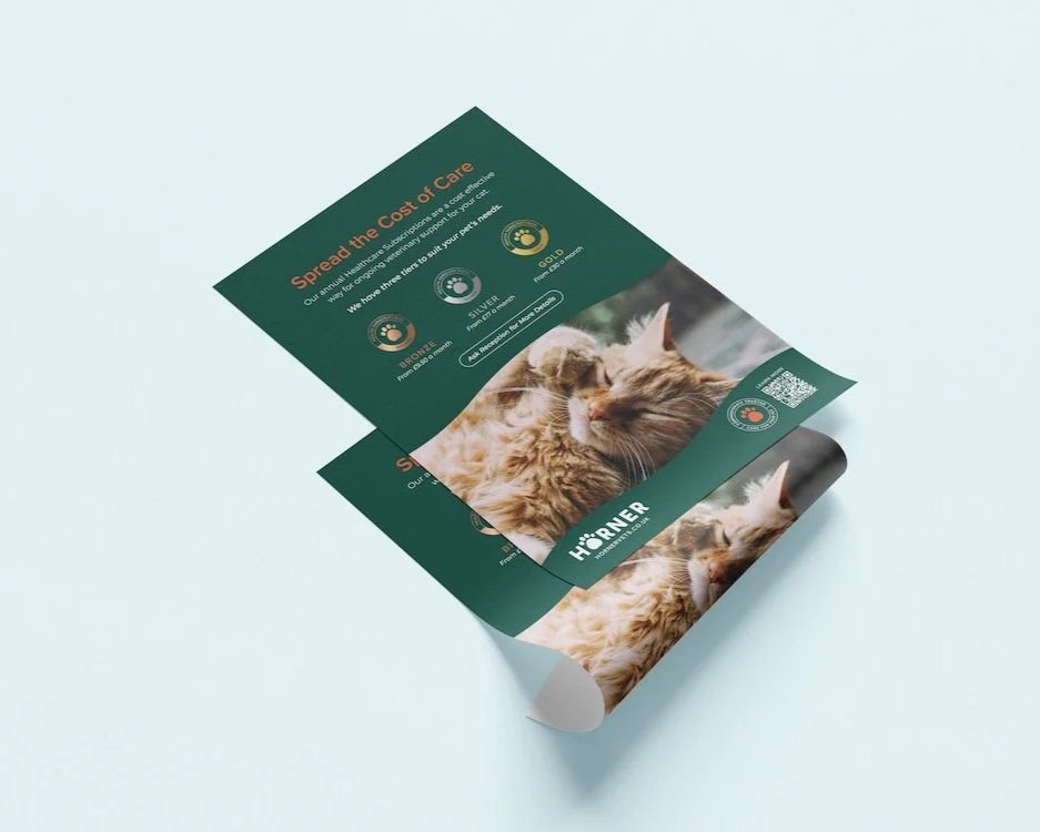 A folded pamphlet featuring a picture of a happy, orange tabby cat and the text 'Spread the Cost of Care' along with information about pet health plans and coverage levels.
