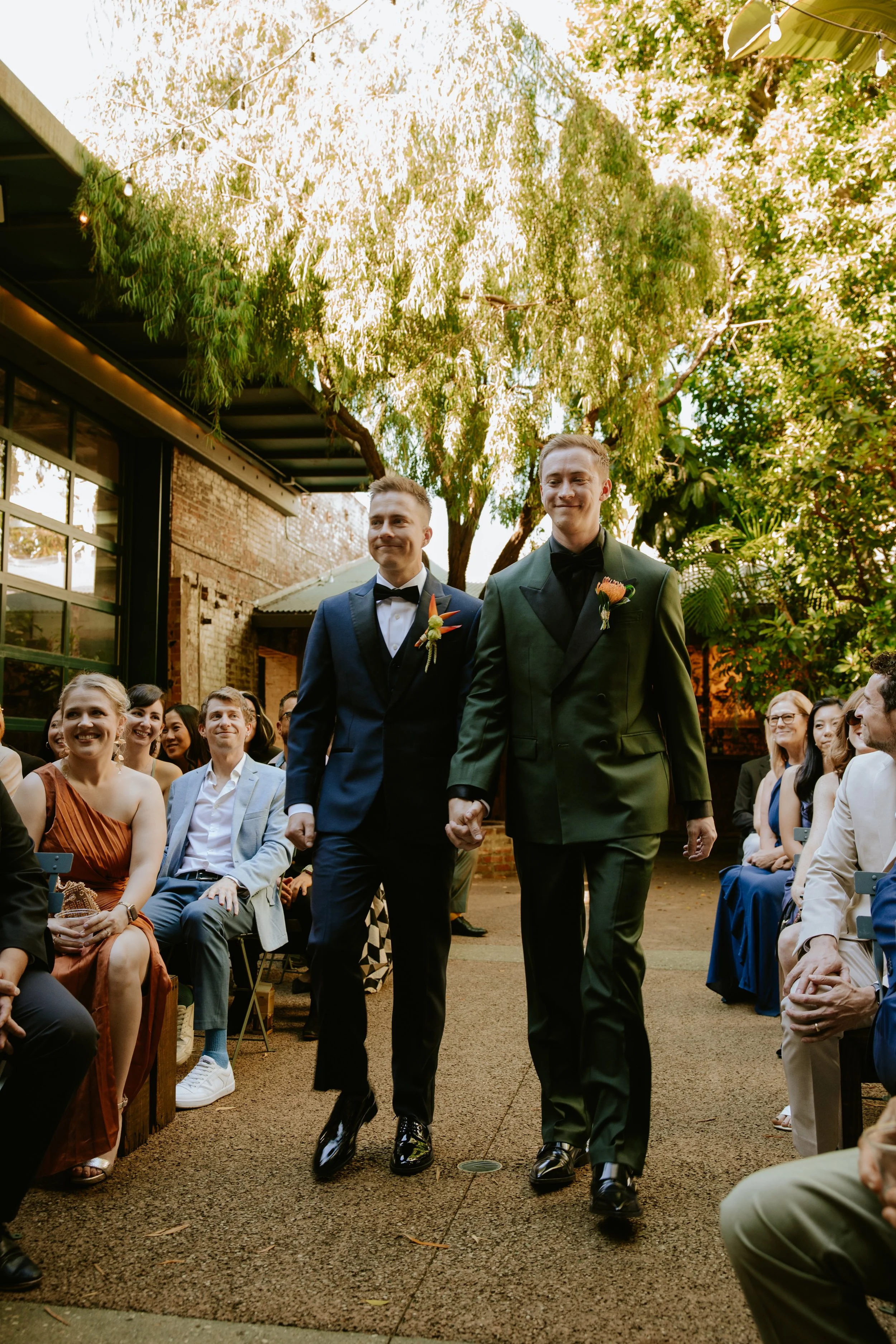 Grooms walking down the aisle holding hands