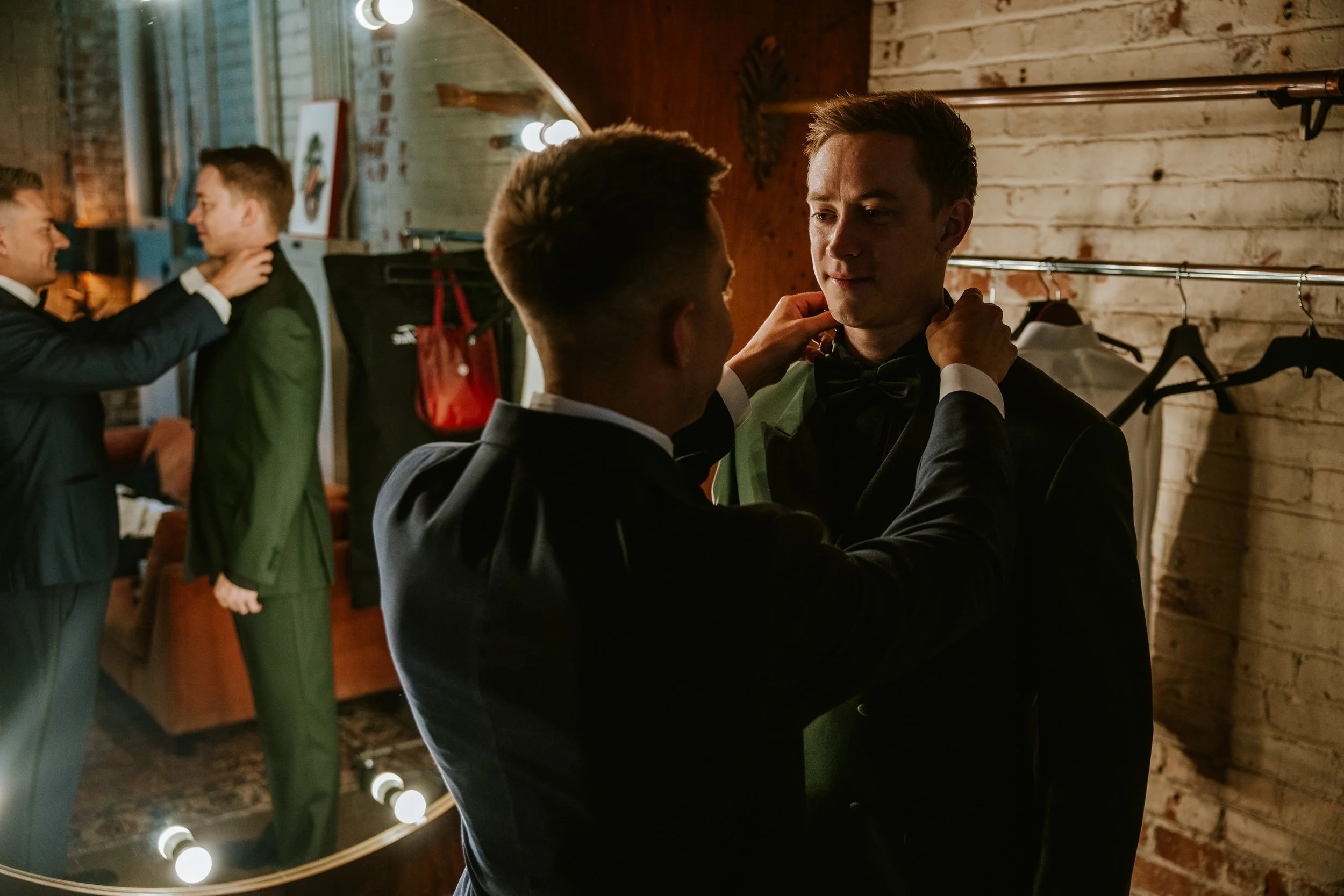 Groom adjusting collar in the green room at Millwick by Marvimon in DTLA