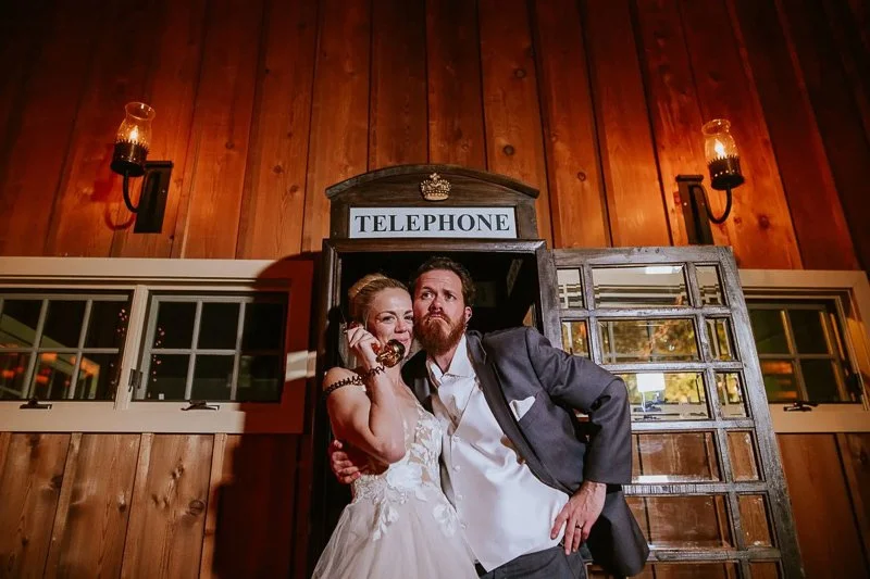 Newly wed couple posing with a telephone booth in Loudoun, Viriginia. Photo by Alex Lee Photography, Virginia Wedding Photographer