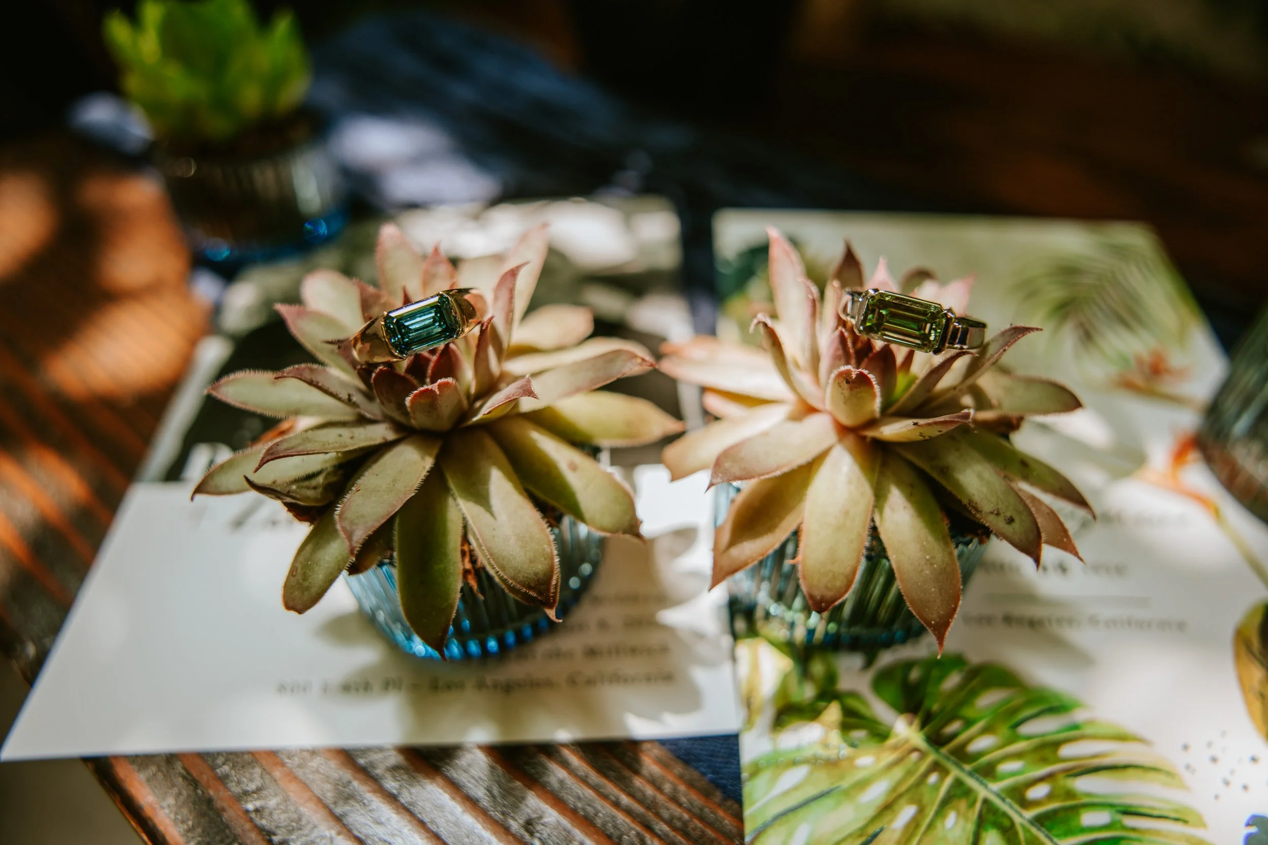 Two wedding rings displayed on top of wedding invitations