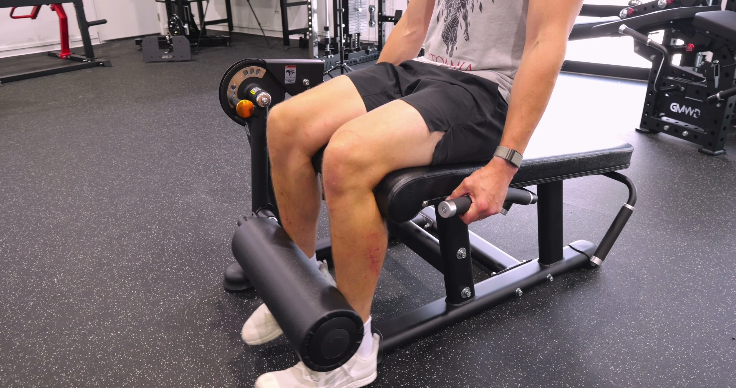 Close-up showing the torso positioning and handle height during a prone leg curl