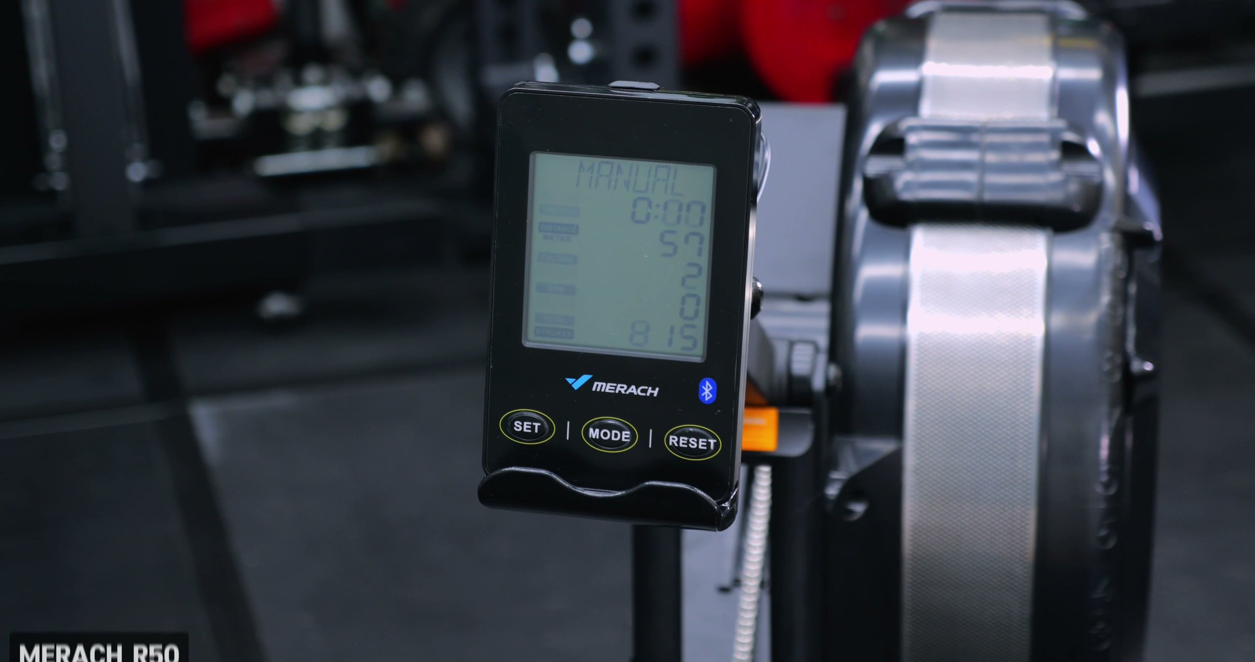 Merach R50 LCD monitor showing rowing metrics with phone holder